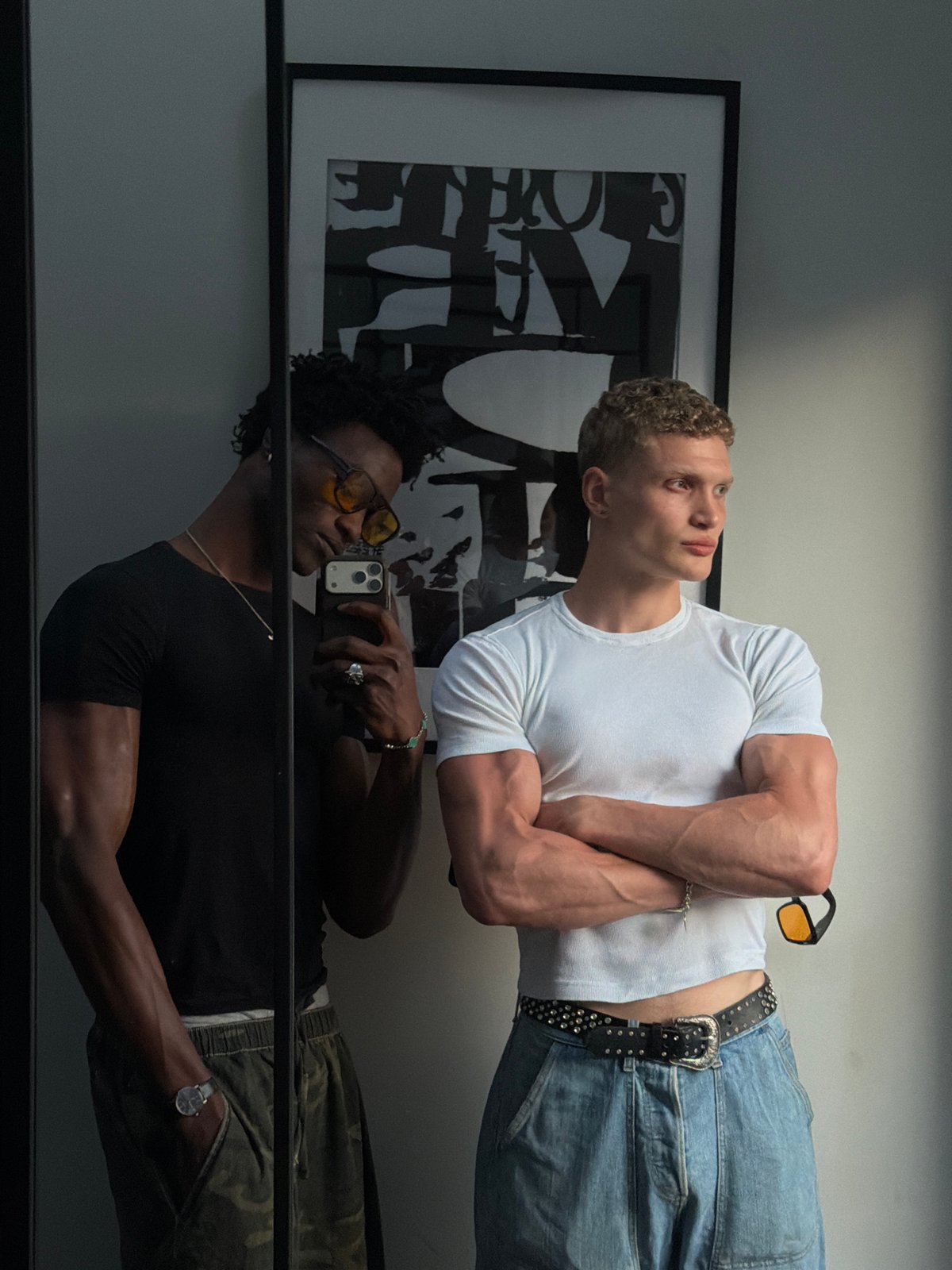 Two men photographed in mirror reflection, London indoor setting