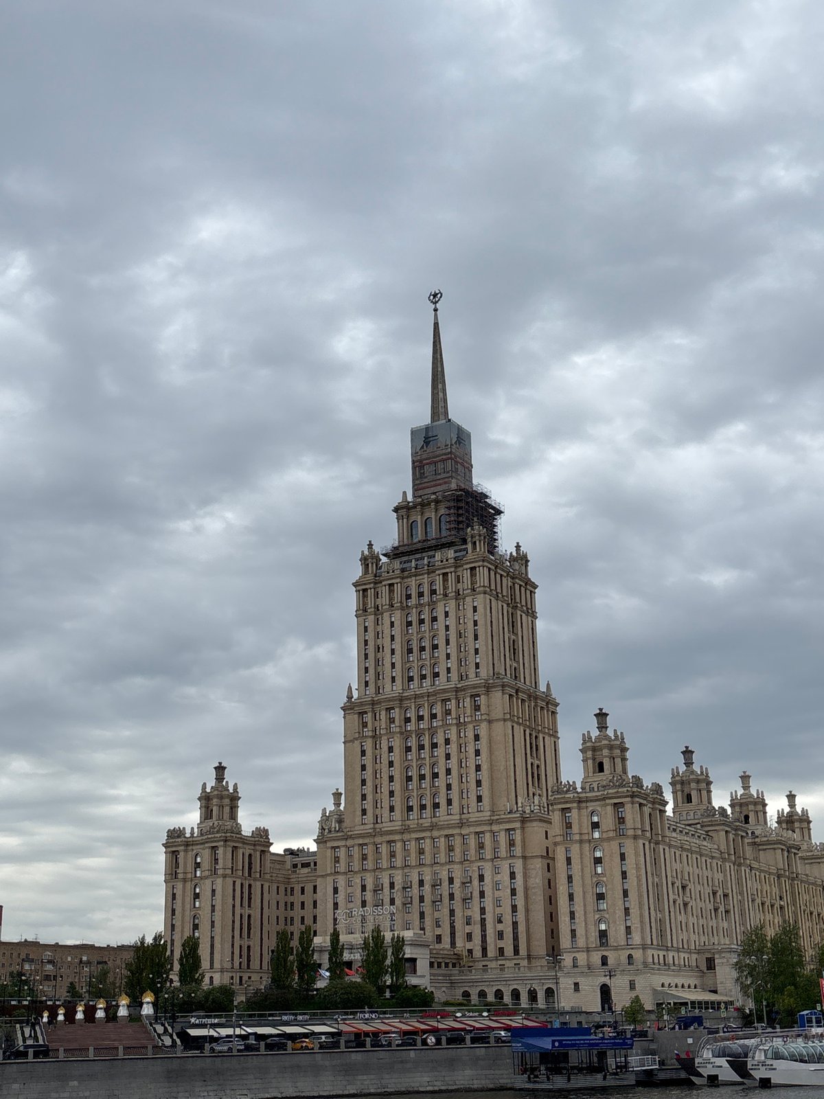 Tourist photographs Moscow State University building during midday visit
