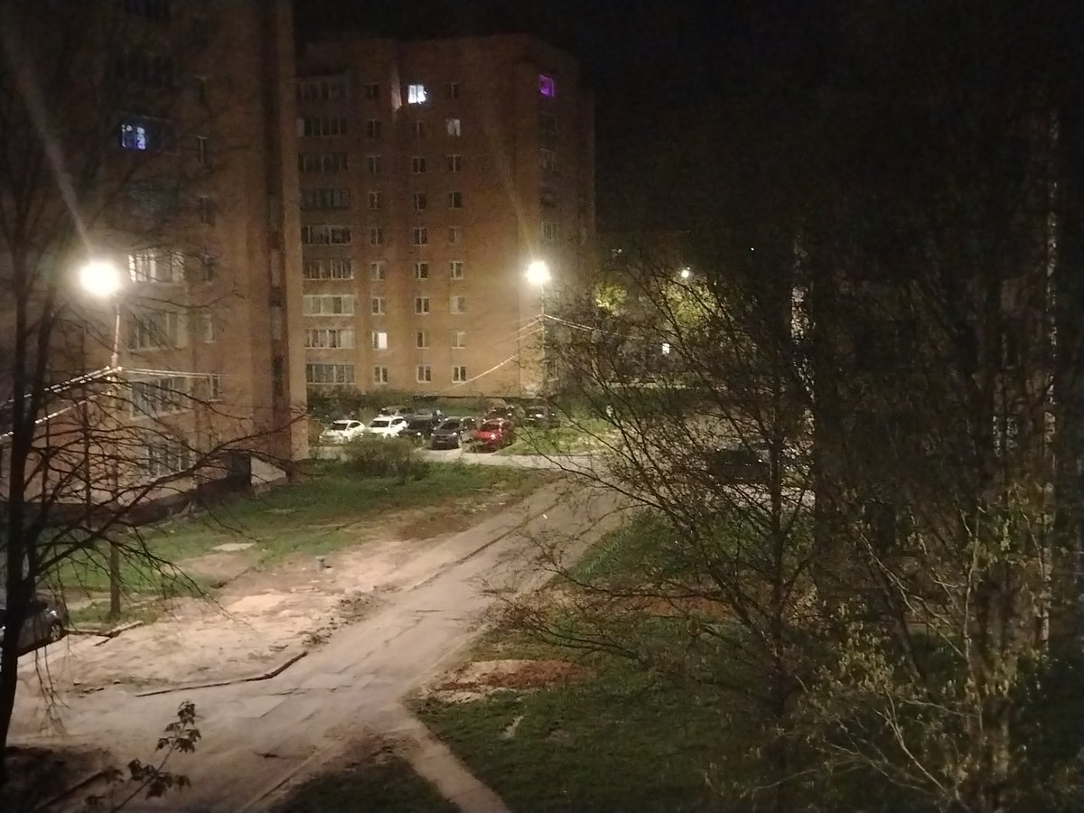 Nighttime urban scene shows two tall brick buildings