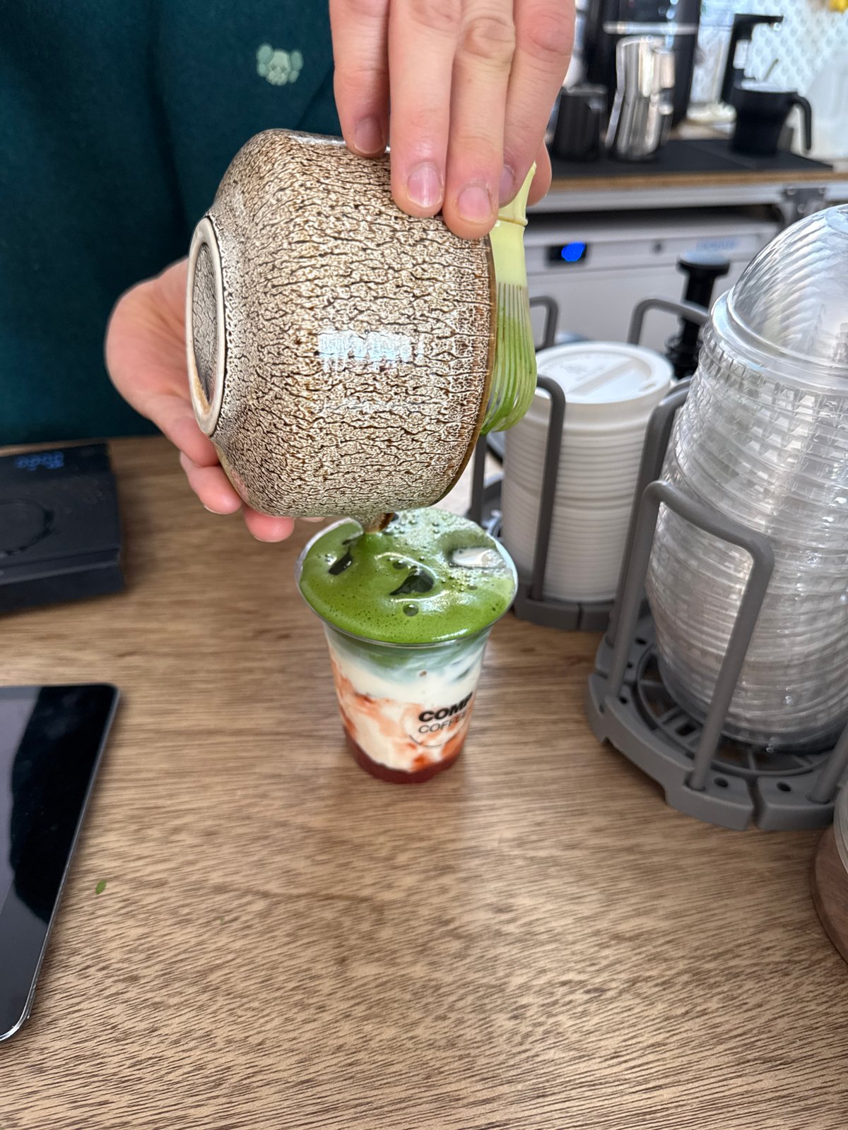 Person handles ceramics at London cafe counter