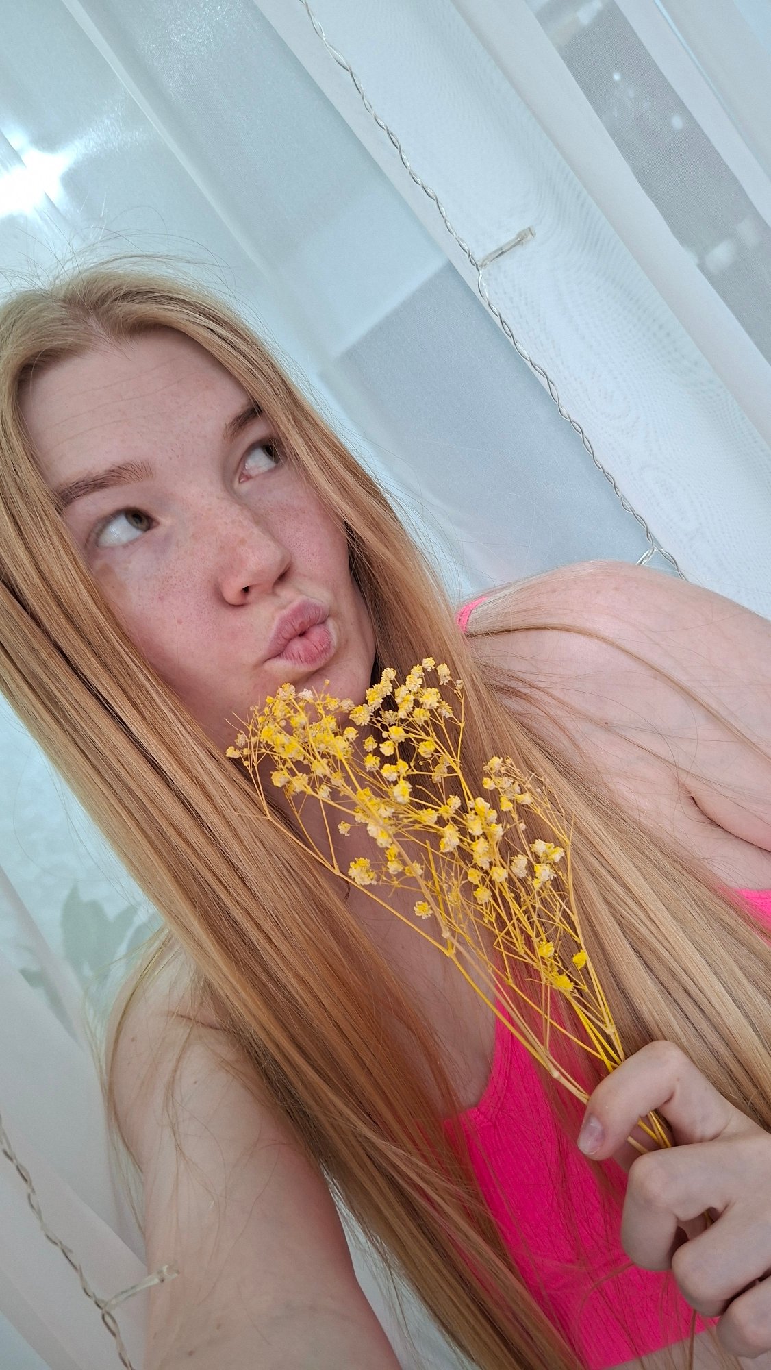 Woman poses with yellow flowers indoors in Chaikovsky, Russia
