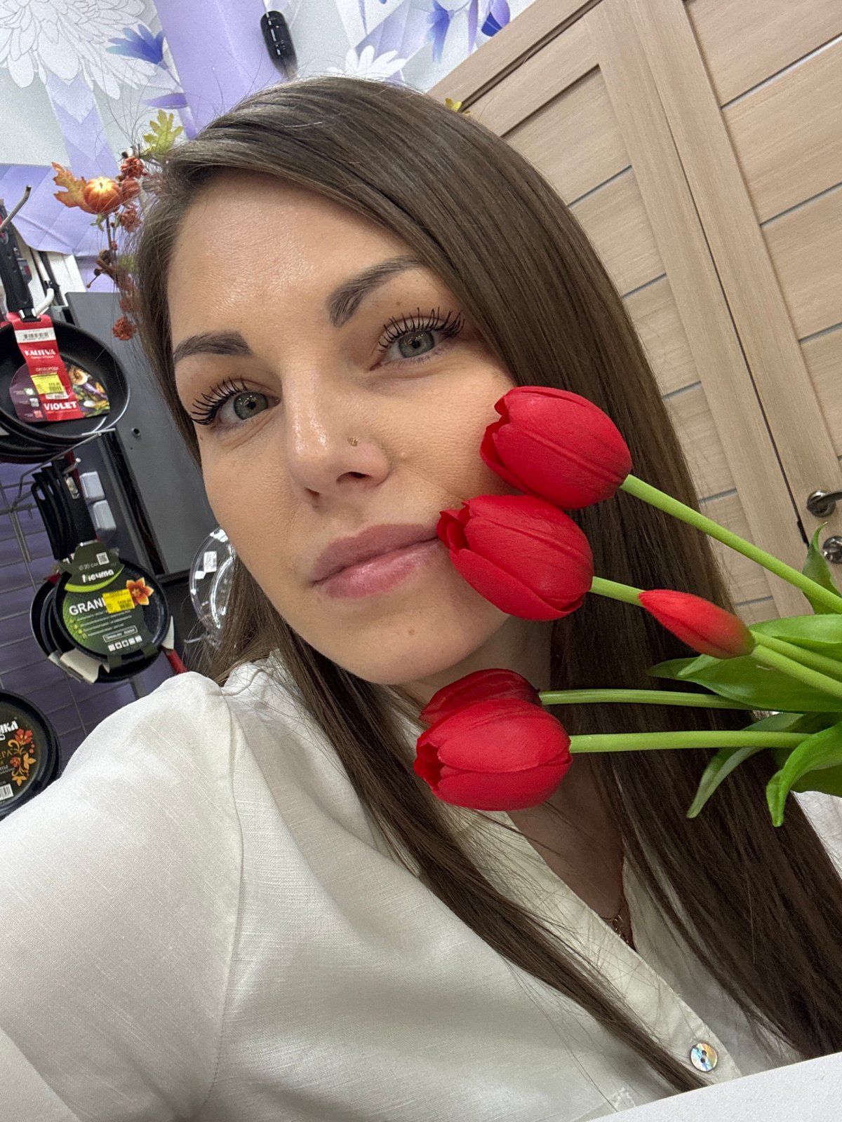 Woman photographs herself with flower bouquets in Klin store