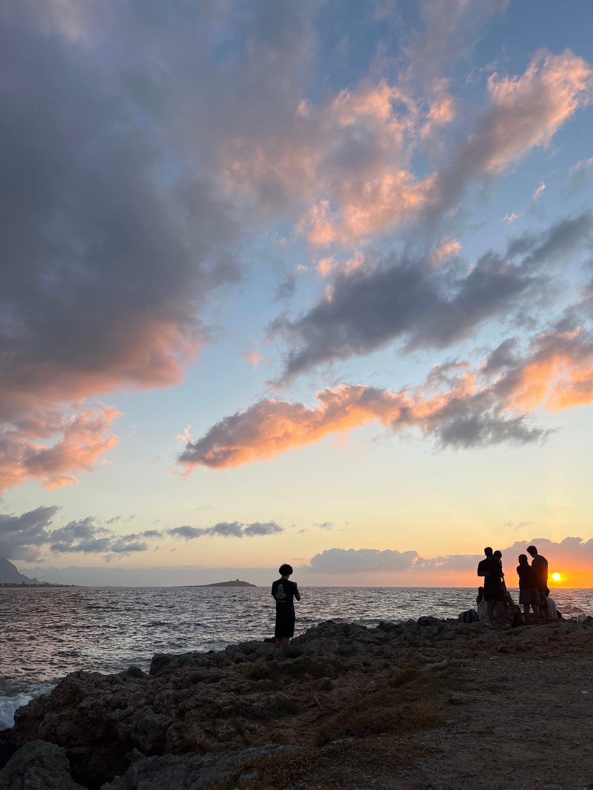 Young people watch sunset from Palermo rocky coastline