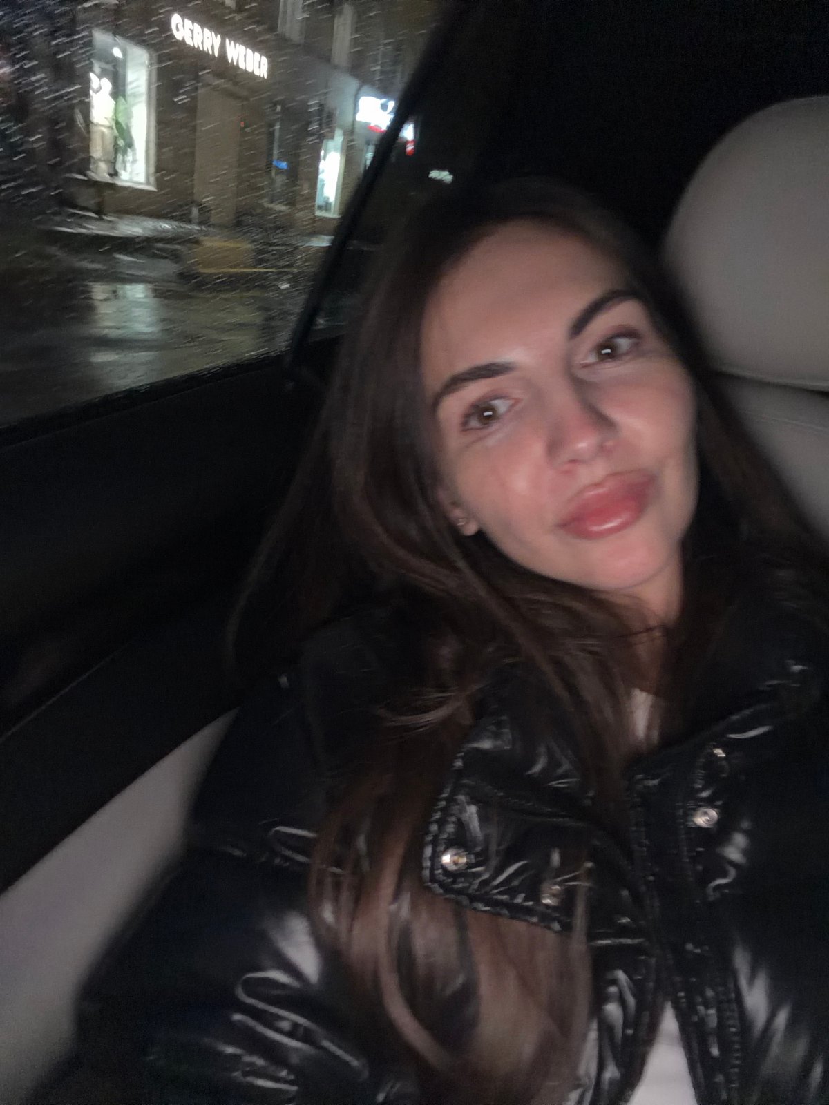 Two women travel by car through rainy Krasnoyarsk afternoon