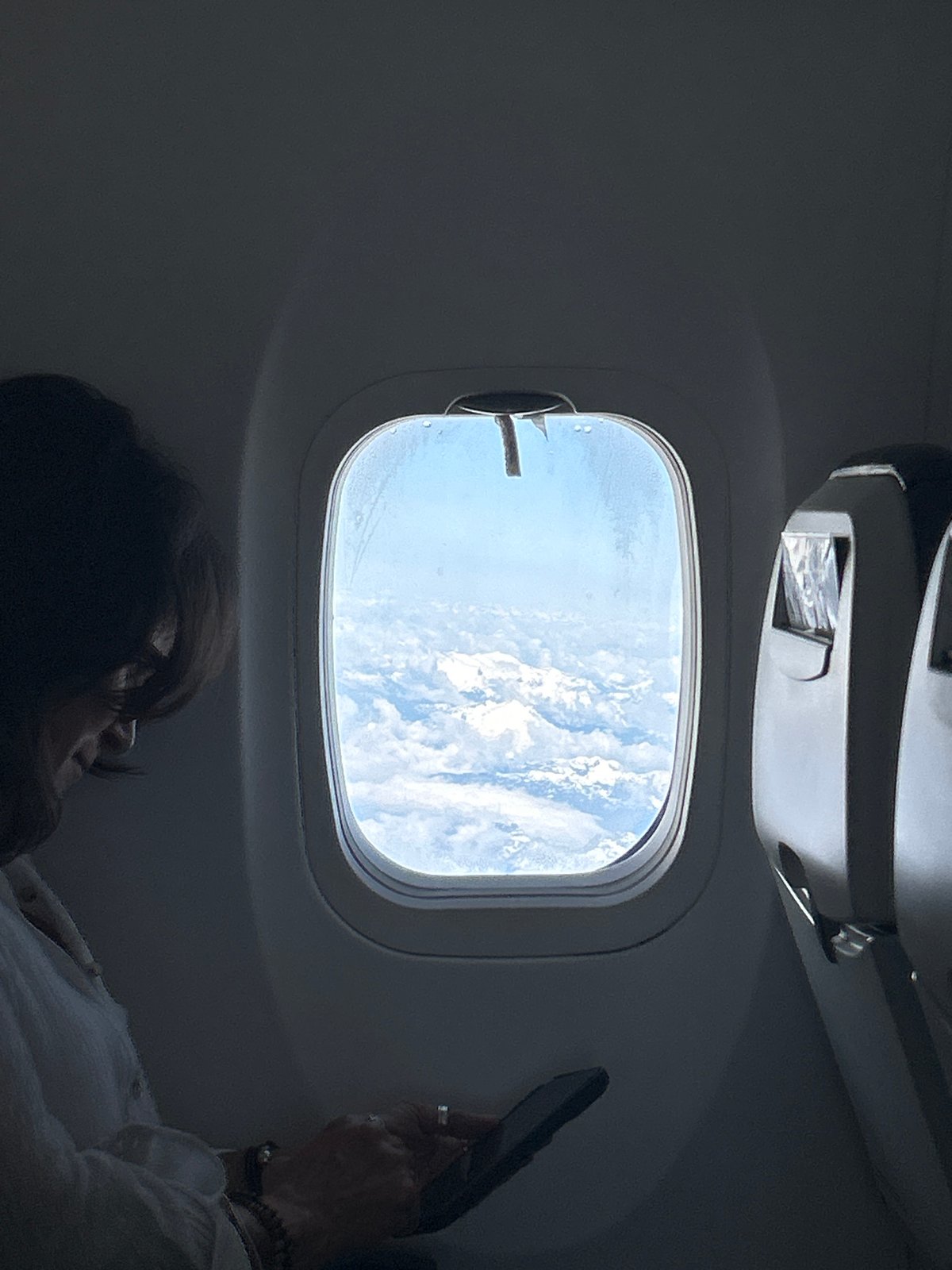 Passenger observed gazing at clouds from airplane window over Canada