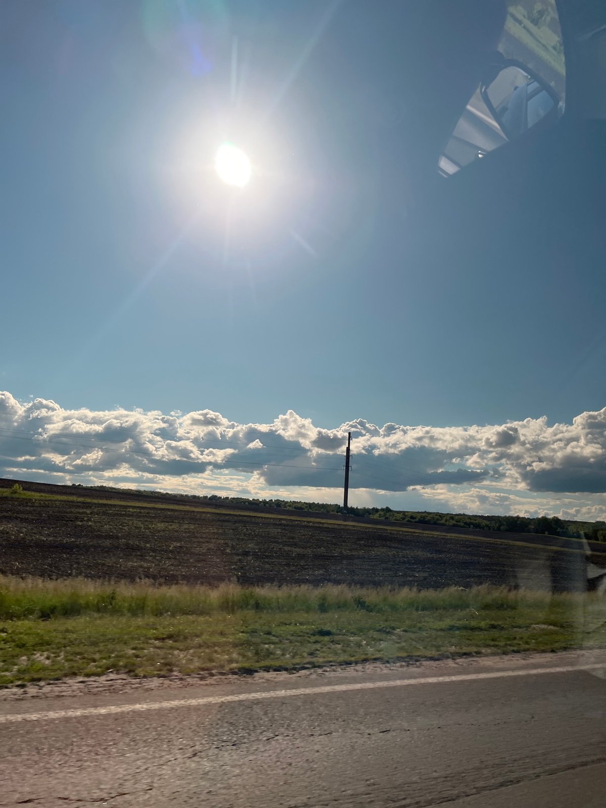 Vehicle journey through sunny rural countryside documented Friday afternoon