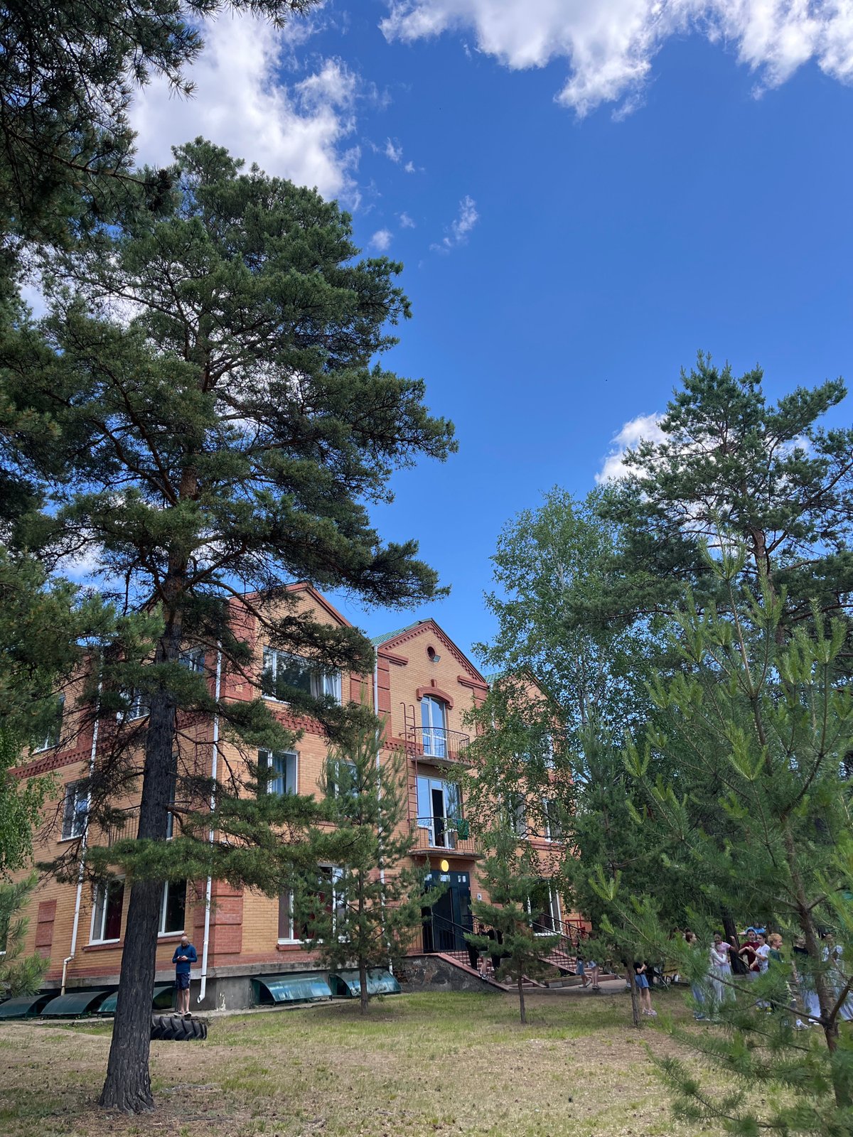 Brick apartment building tucked into a pine grove, Krasnoturansk