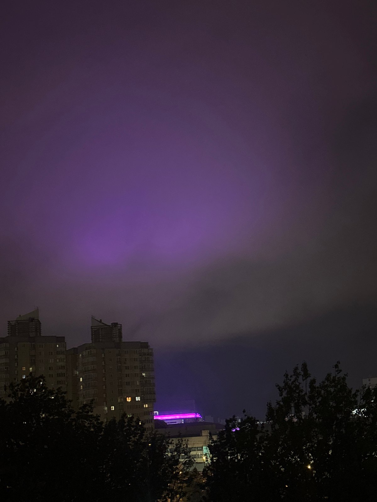 Foggy night illuminates purple-lit building in Minsk