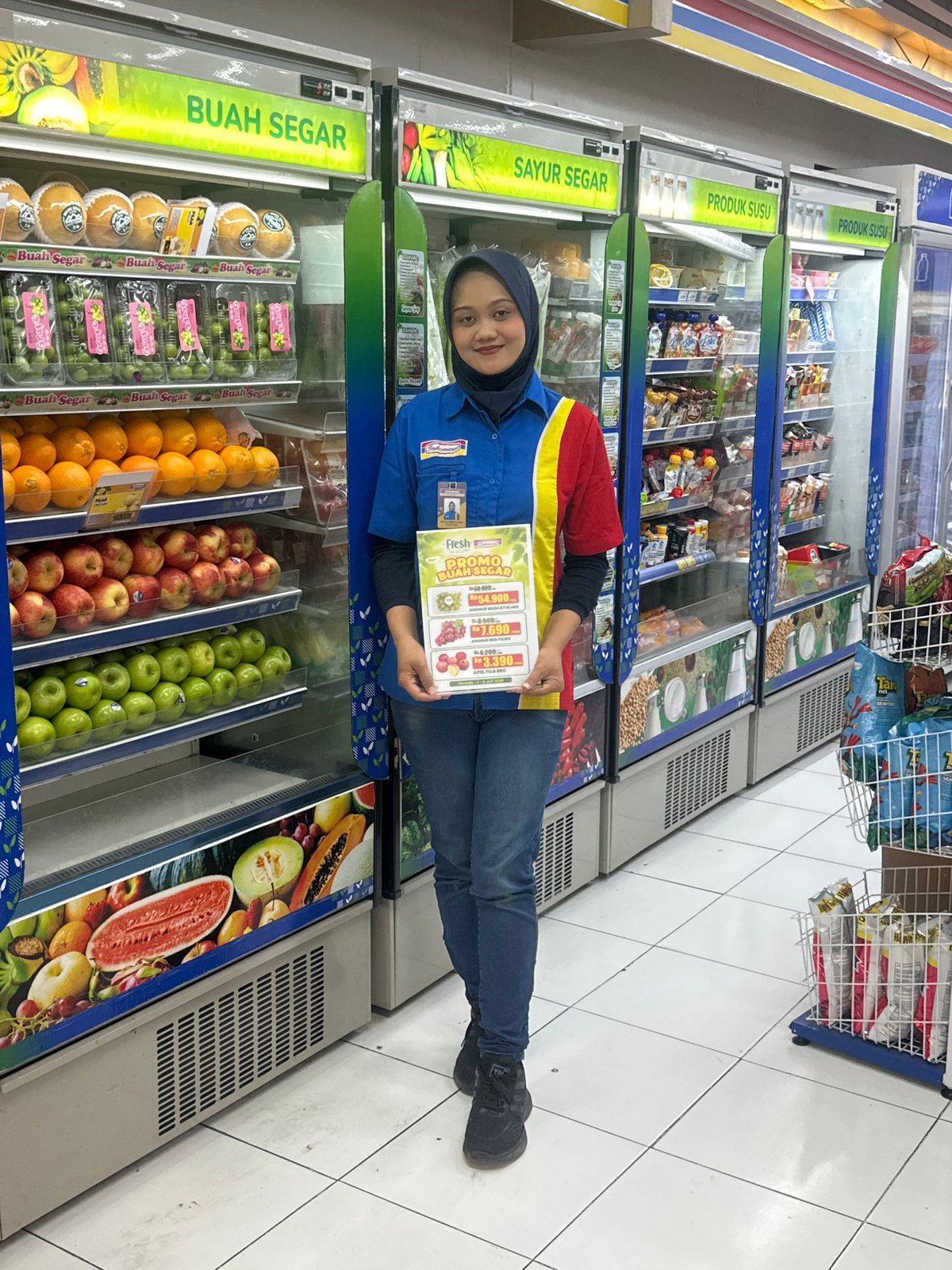 Convenience store worker near fresh produce fridge in North Kuta