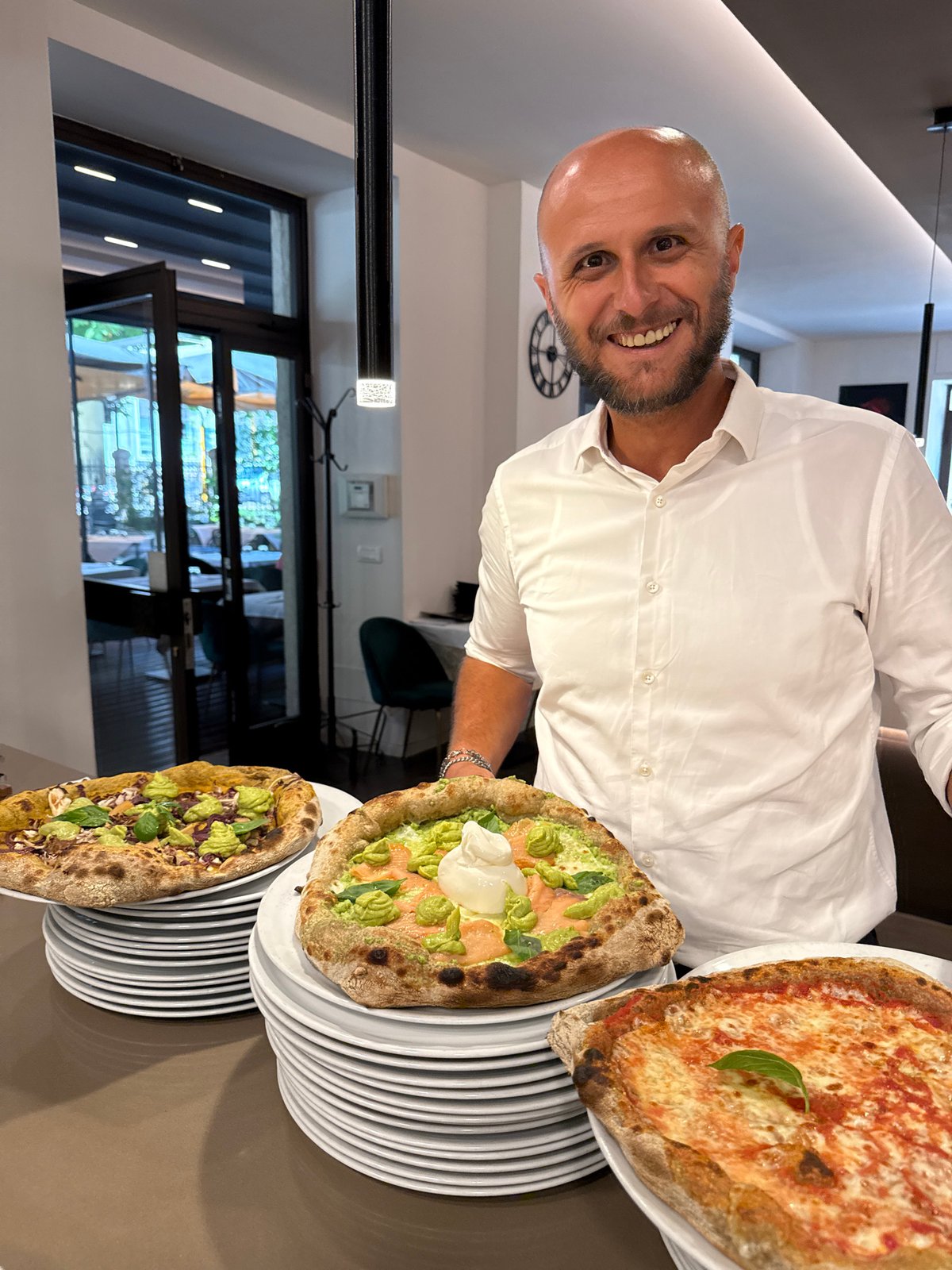 Fresh Neapolitan pizzas coming out of a dome oven in Trento