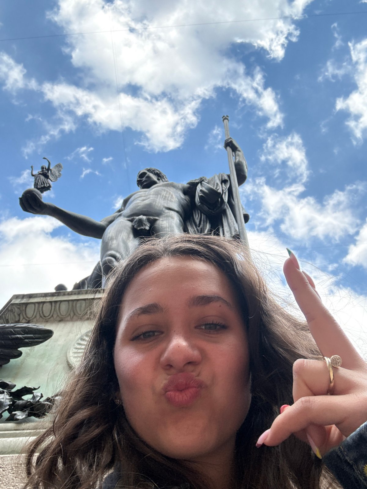Tourists gather at Milan historic courtyard, pose with bronze statue
