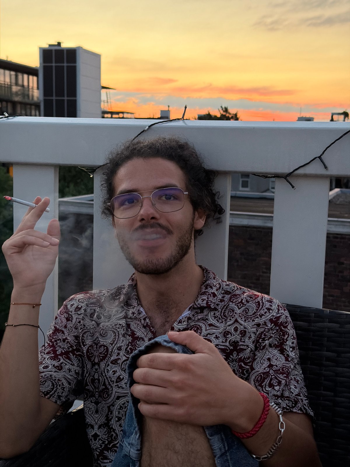 Amsterdam rooftop at golden hour, city skyline at dusk
