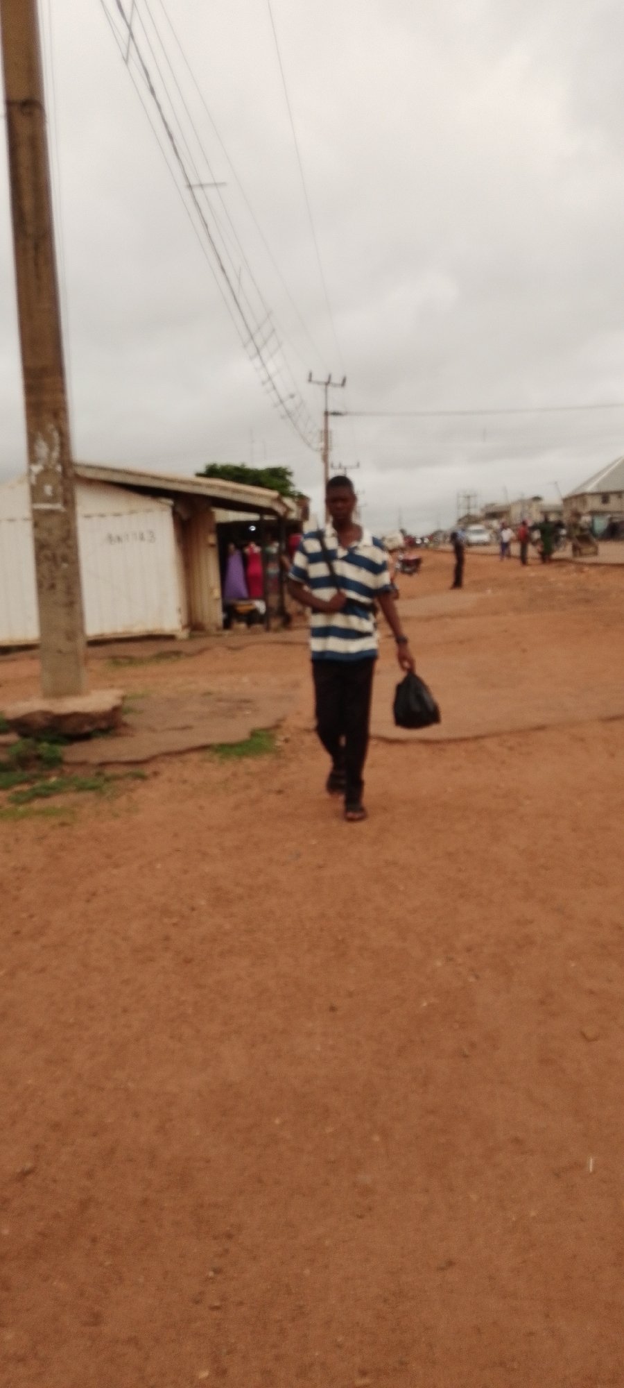 Morning street life along a busy dirt road in Gboko, Nigeria
