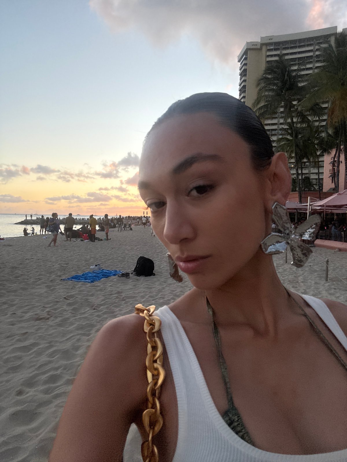 Sunset crowd gathers along Honolulu waterfront beneath palm trees