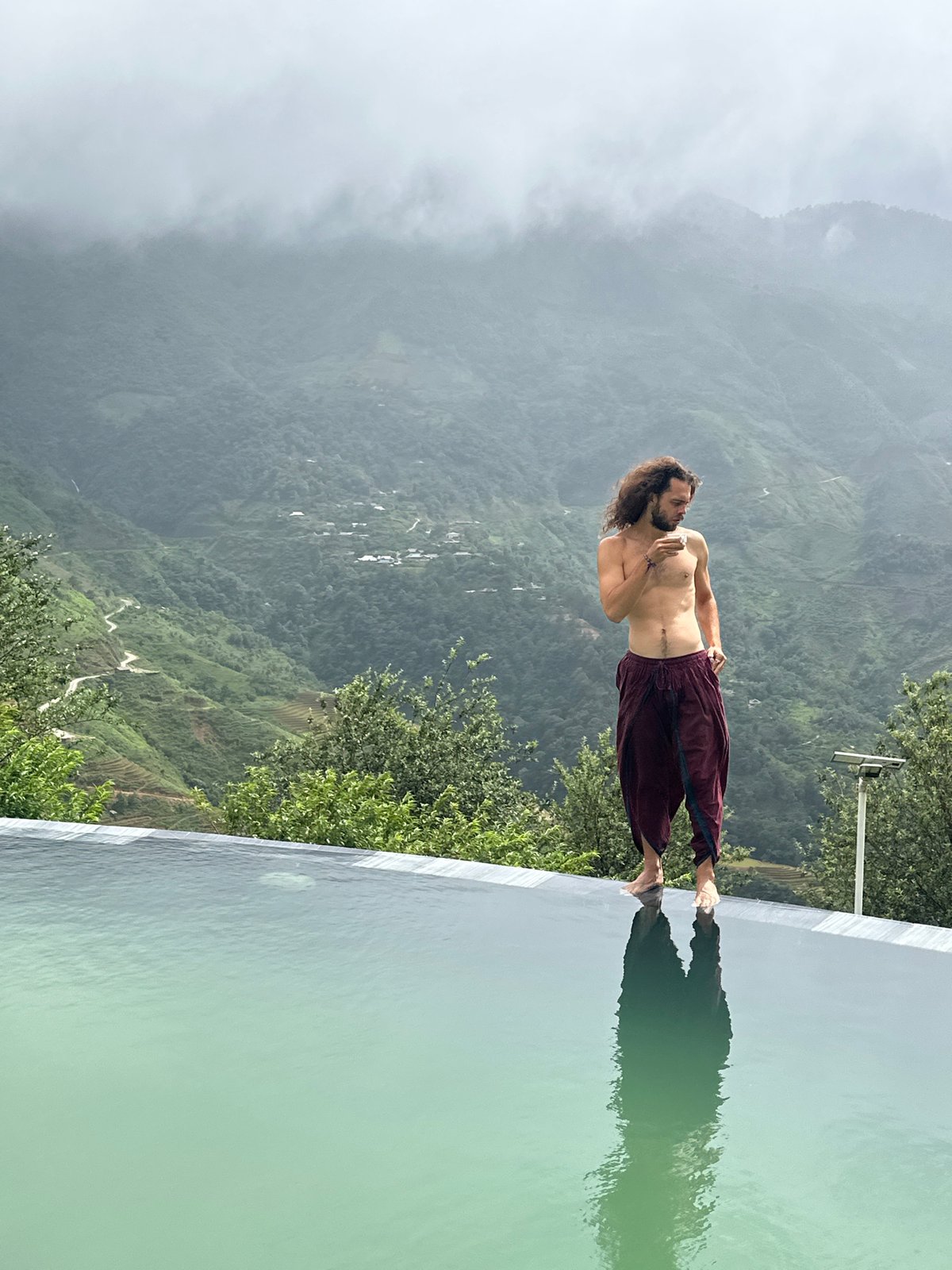 Man stands at infinity pool edge in Ta Xua