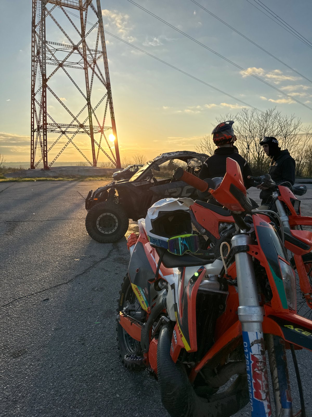 Off-road enthusiasts gather near Bulgarian pylon during sunset