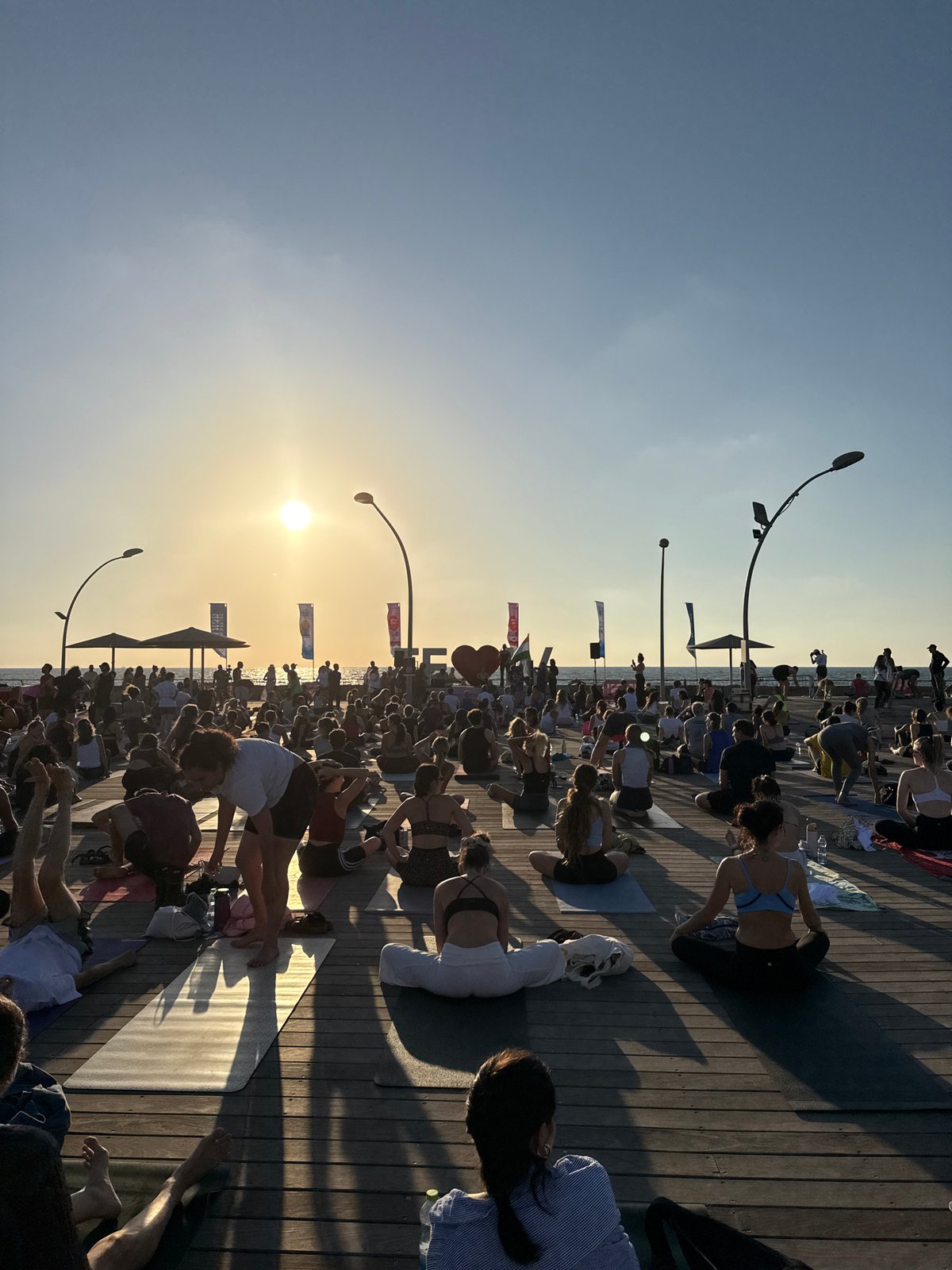 Group yoga session on a Tel Aviv waterfront deck