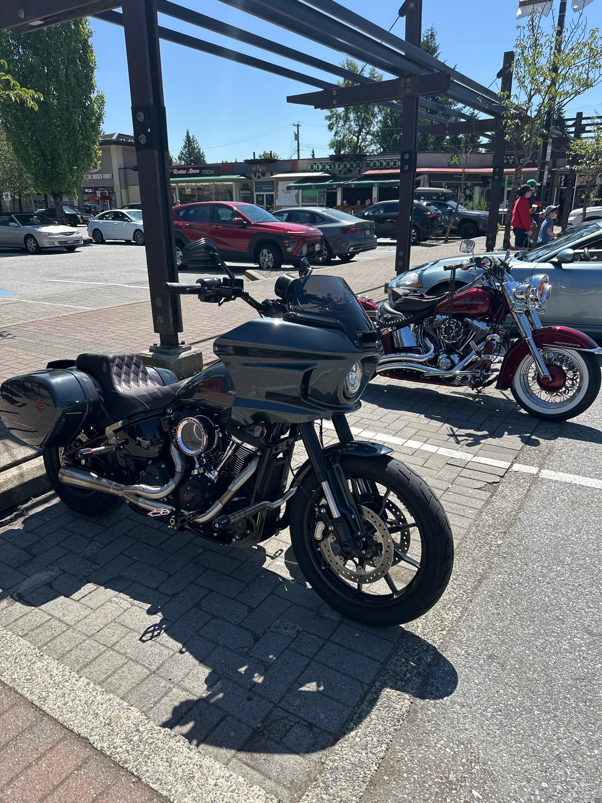 Two Harley-Davidson motorcycles parked on Coquitlam brick sidewalk