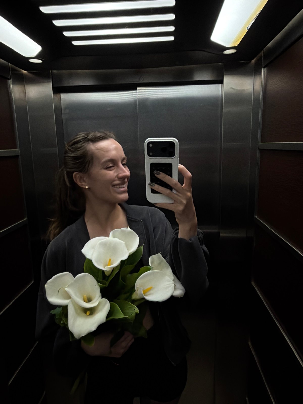 Woman takes elevator selfie with flowers in Budva