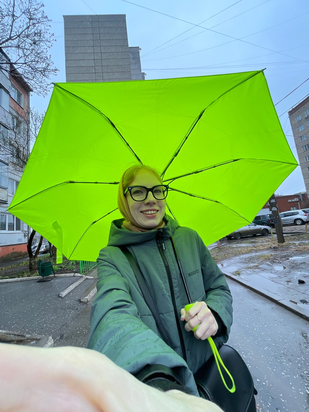 Woman with green umbrella photographed on rainy Izhevsk streets