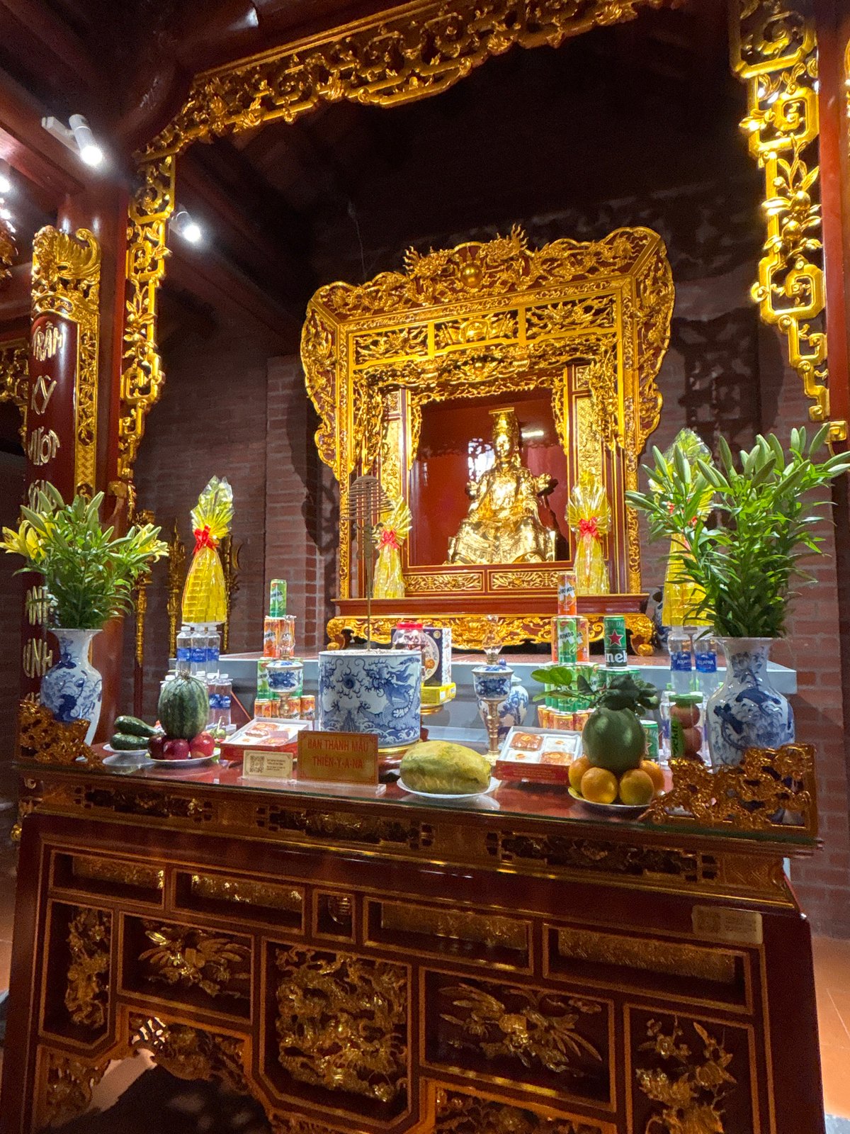 Inside a Vietnamese Buddhist temple, altars dressed with offerings