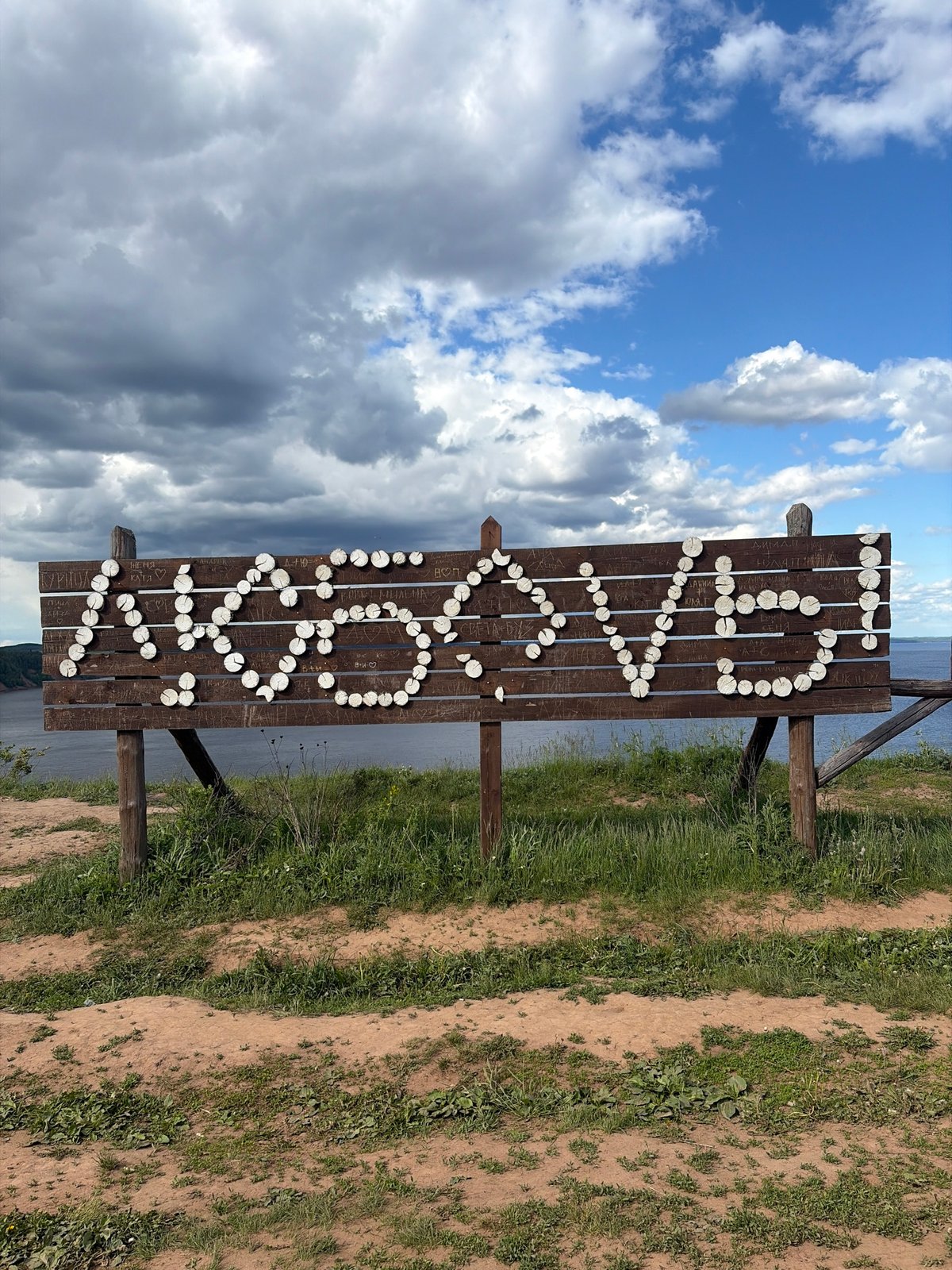 Scenic waterfront views and wooden signage captured in Костоваты