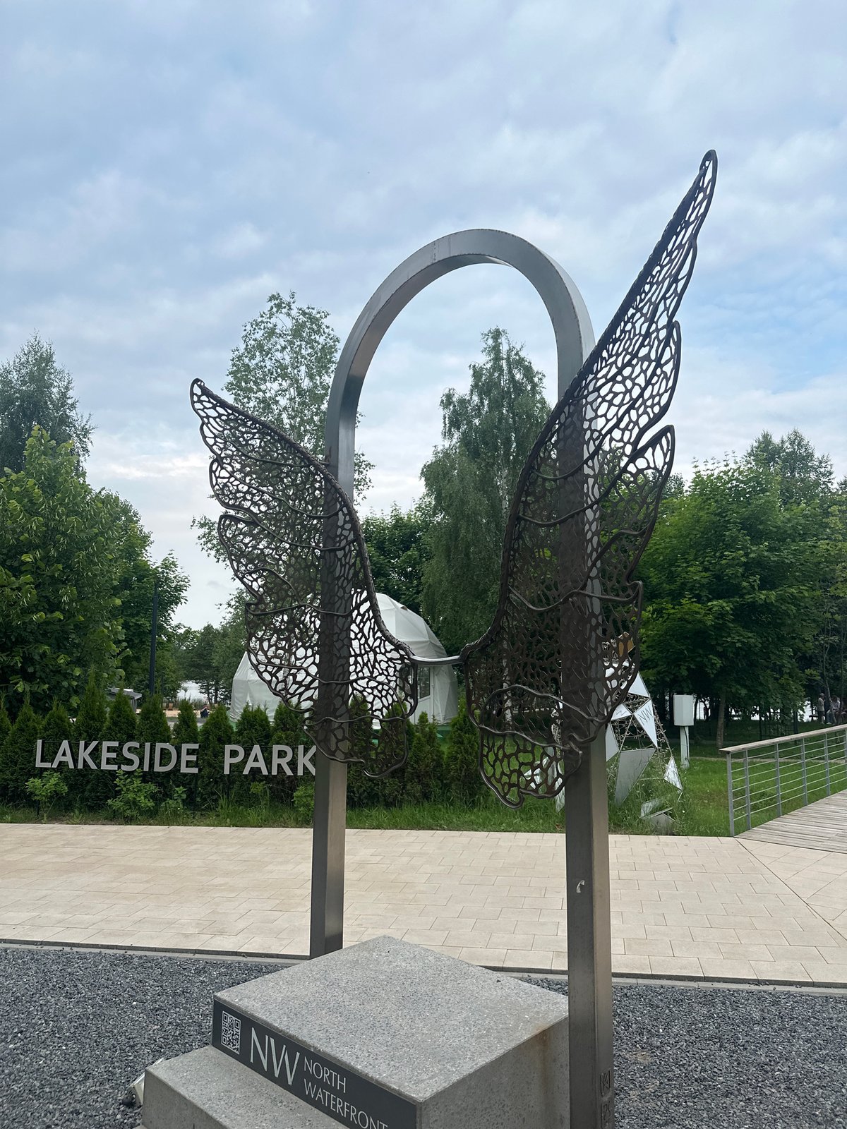 Visitor documents sculptures and wildlife during Minsk park afternoon stroll