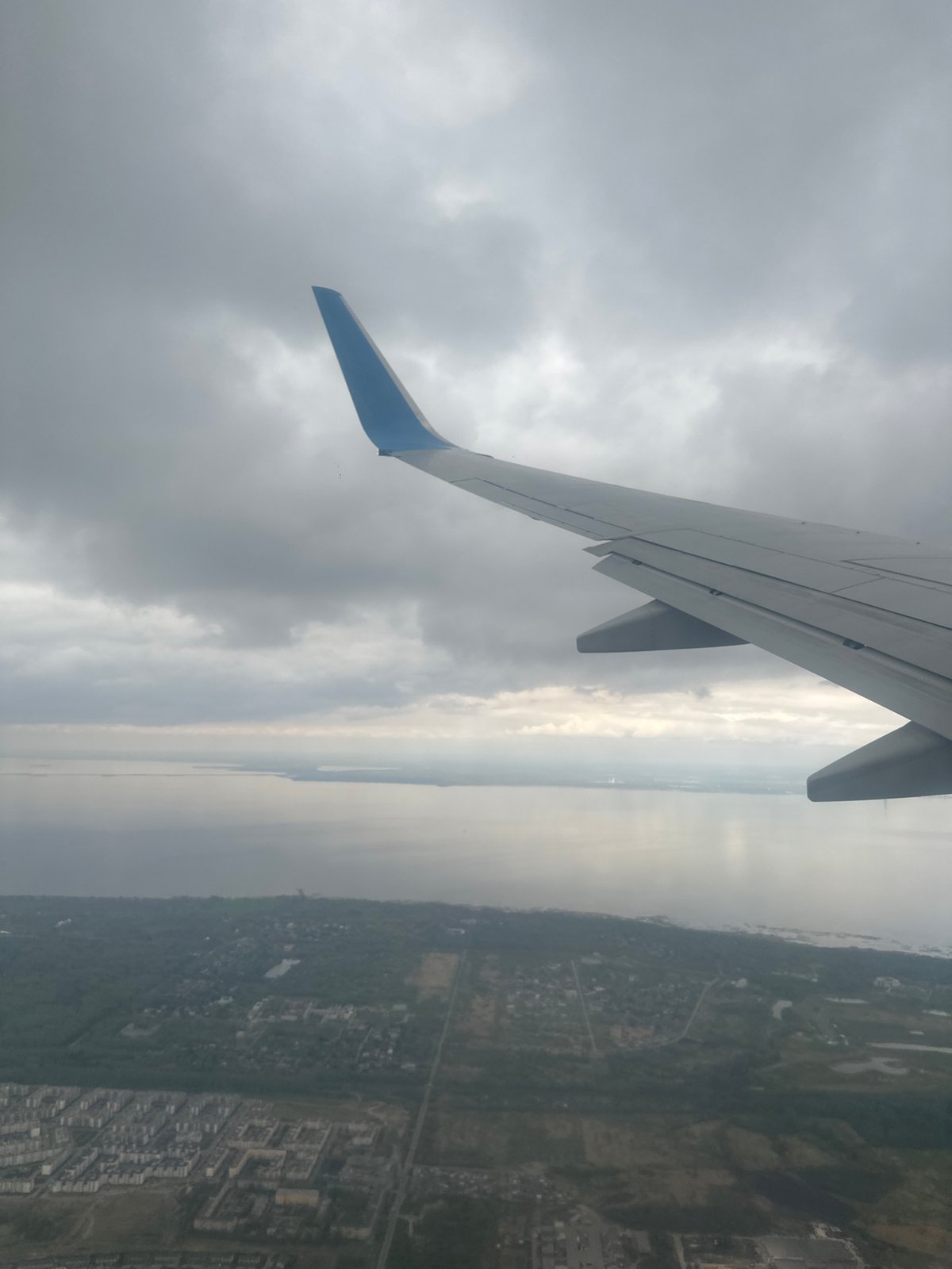 Passenger documents aerial view of coastal Russian city from airplane