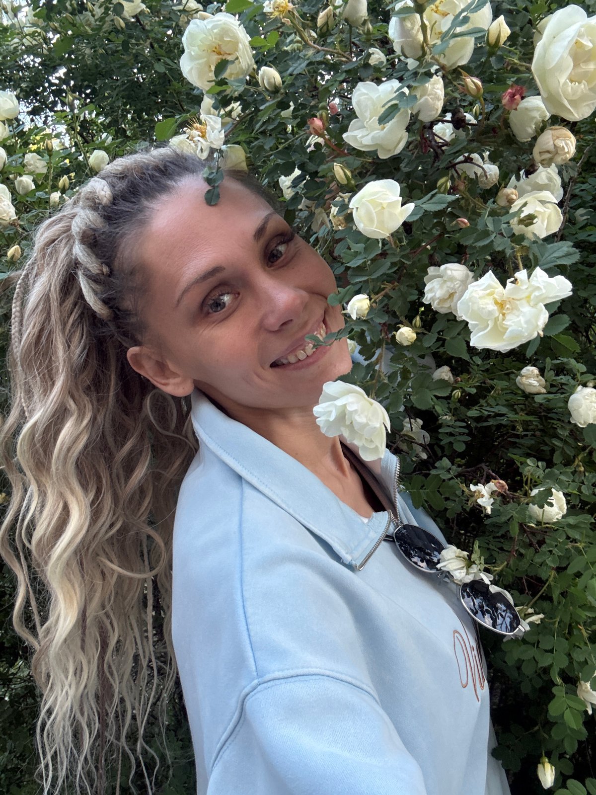 Woman travels between Russian towns, poses near roses and waves from boat