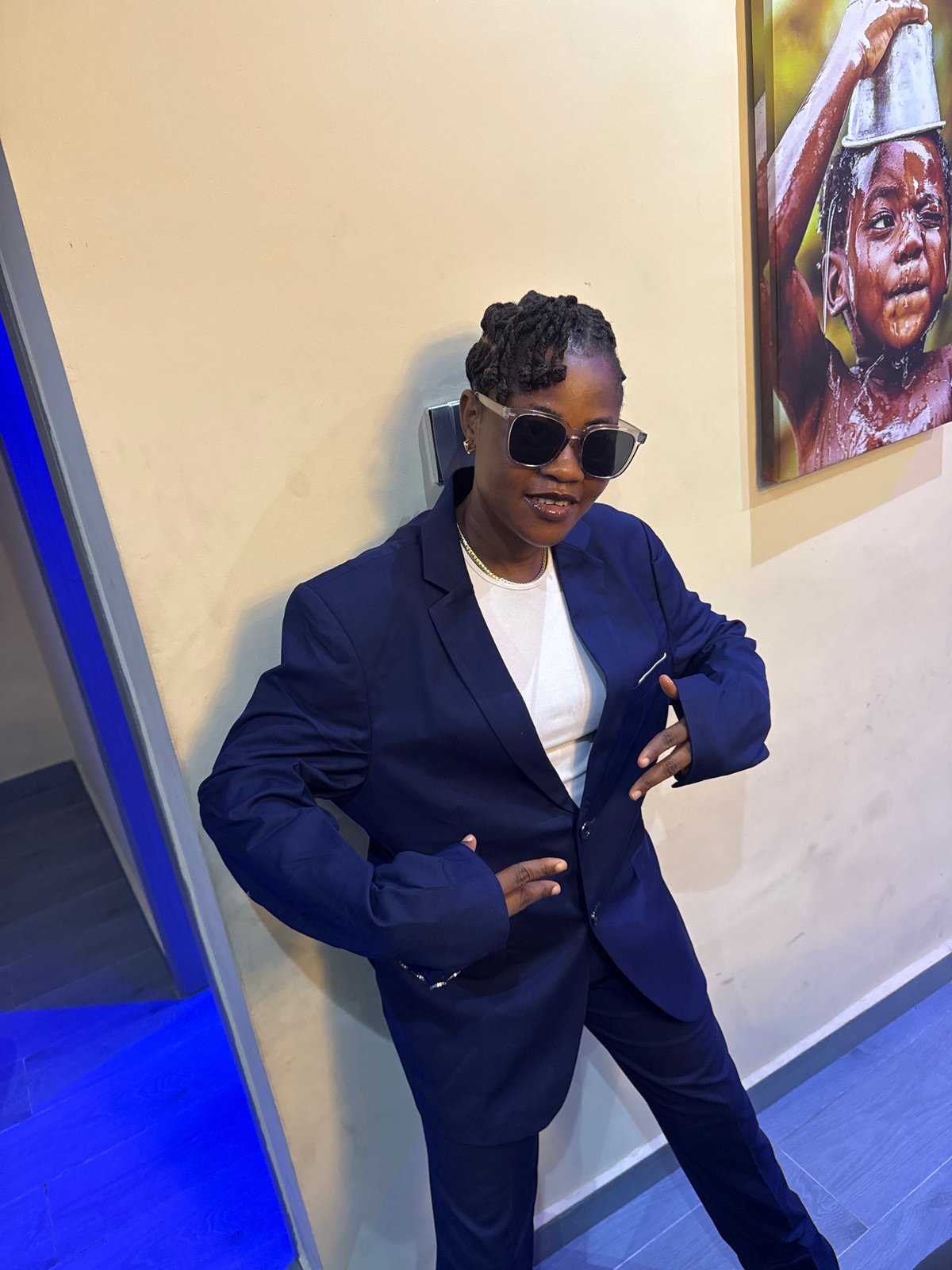 Woman in navy suit poses with boxes in Ajara