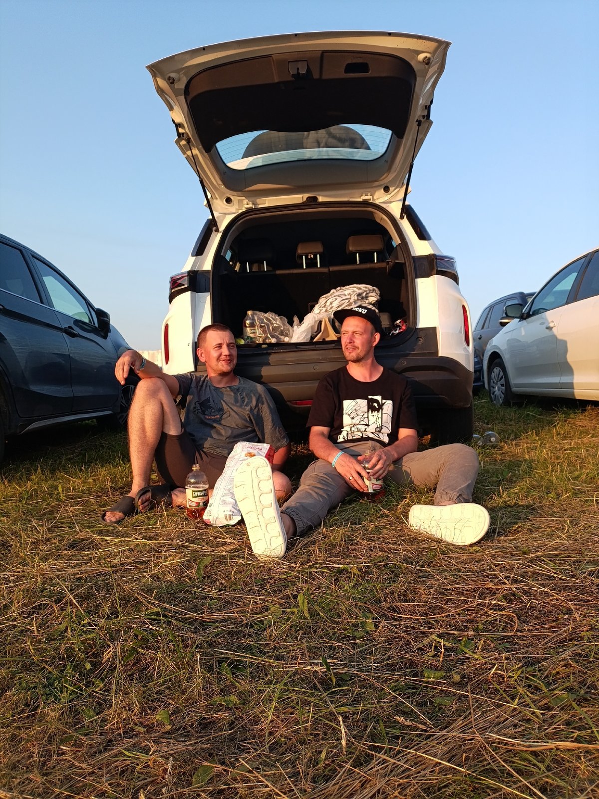 Vehicles and riders take a break in a Russian field at sunset