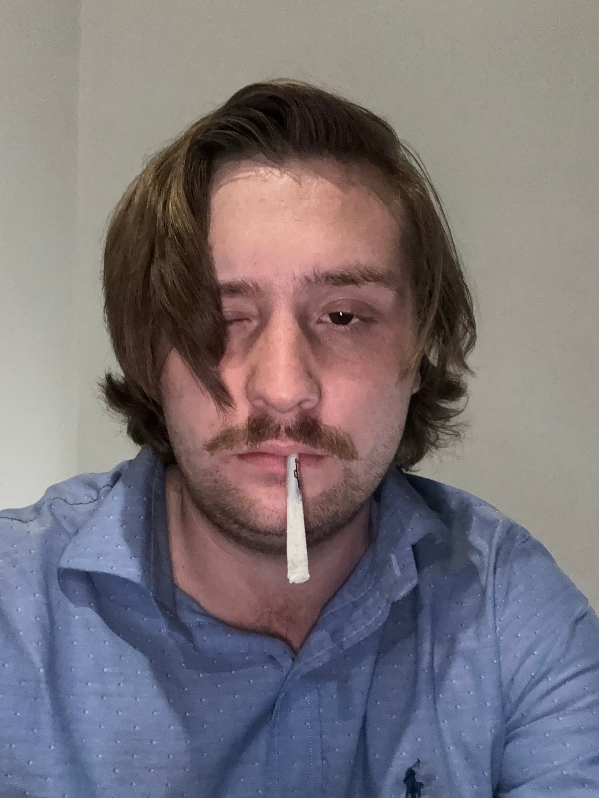 Person photographed with cigarette, blue object in Huixquilucan