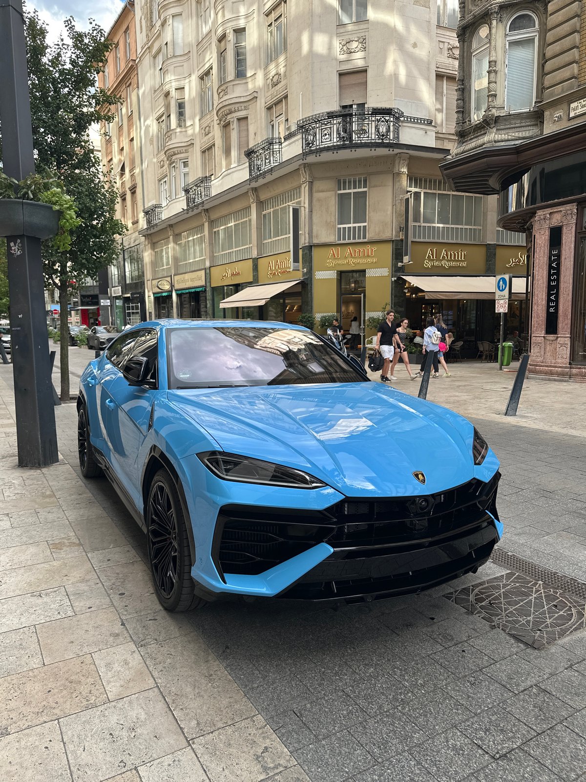 Bright blue Lamborghini Urus parked on a Budapest street