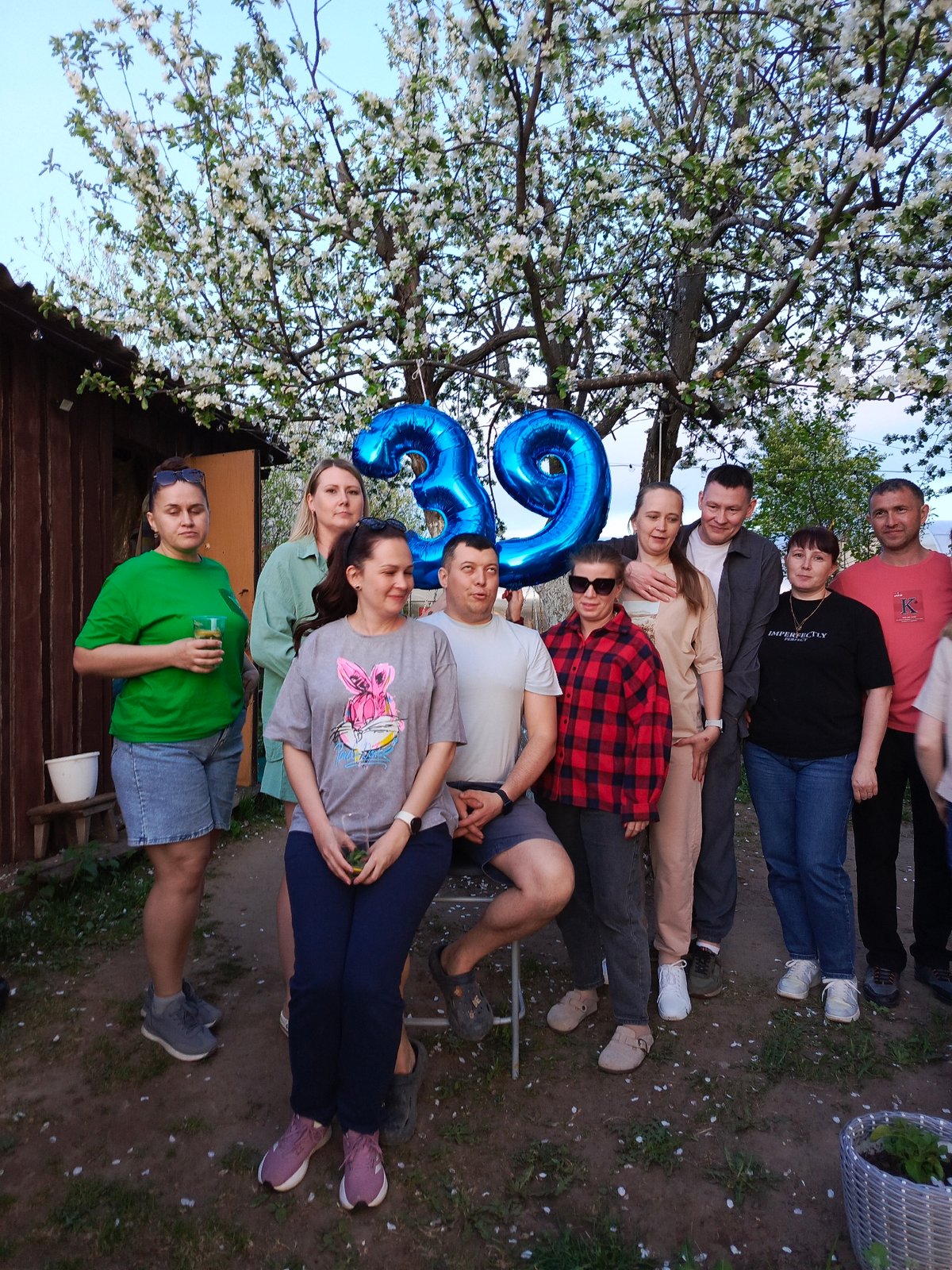 Ten people gather in backyard, location unknown