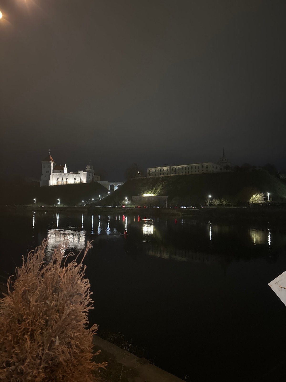 Illuminated Old Castle reflects on Neman River in Hrodna