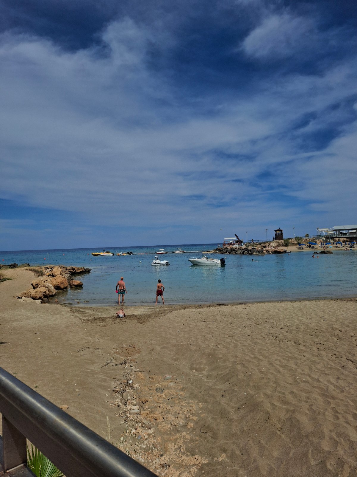 Two beachgoers wade in Fig Tree Bay waters, Cyprus
