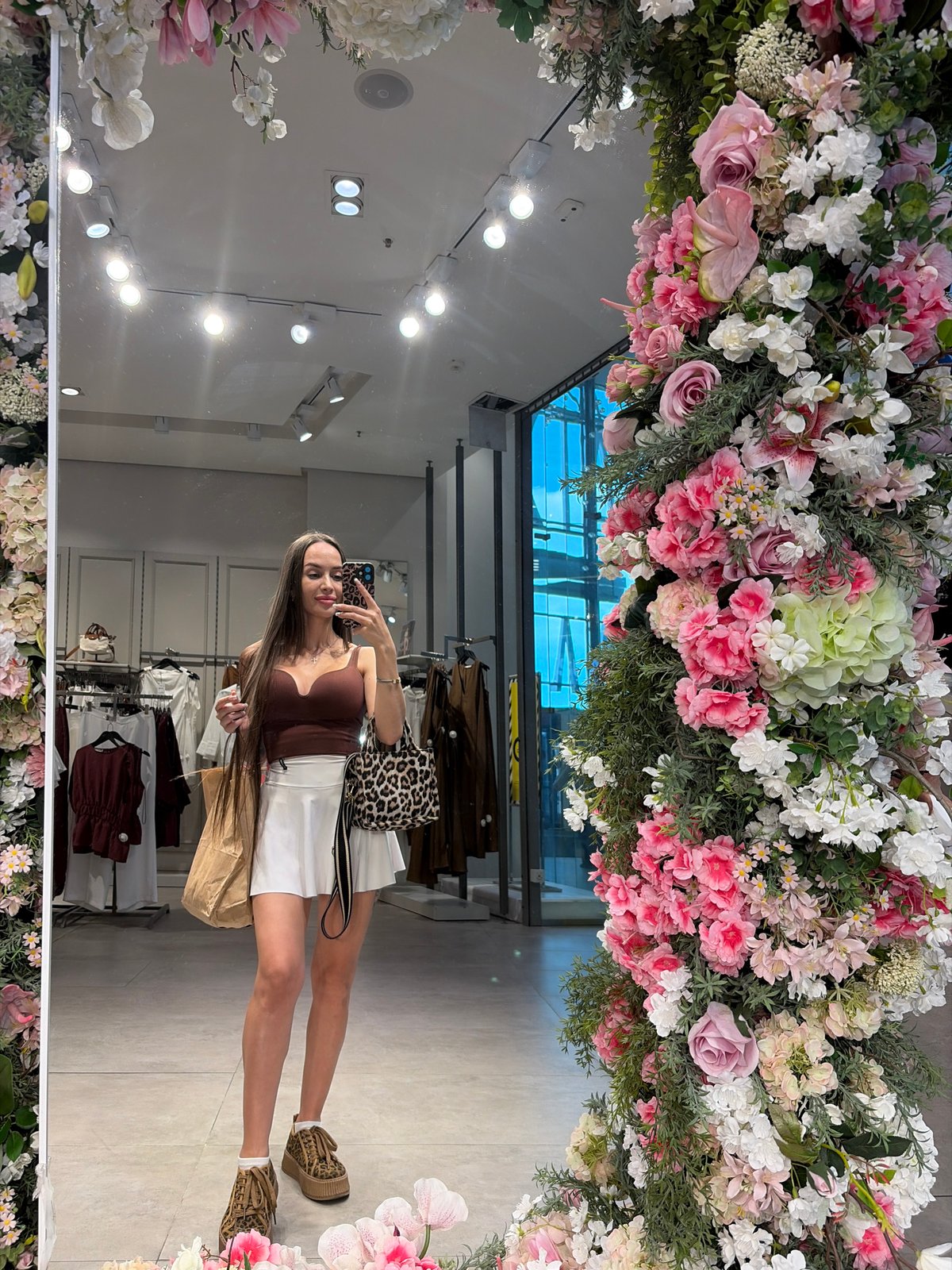 Mirror selfie in a Saint Petersburg clothing store, bags in hand