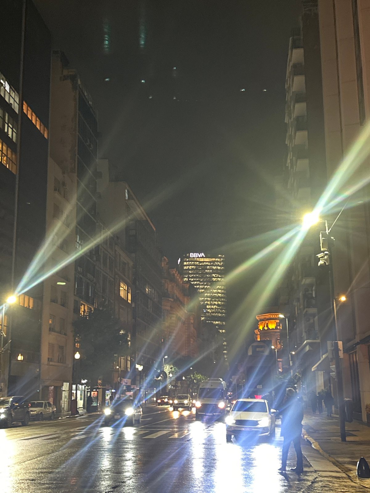 Rainy night scene captured in Buenos Aires featuring BBVA building