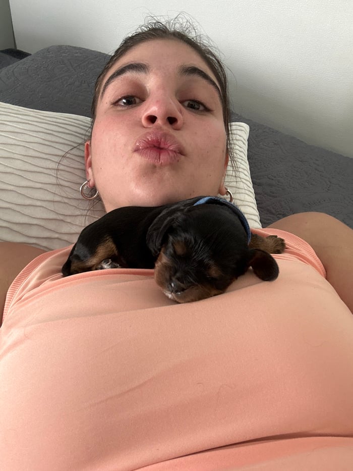Woman poses with newborn puppies in Puebla photo session