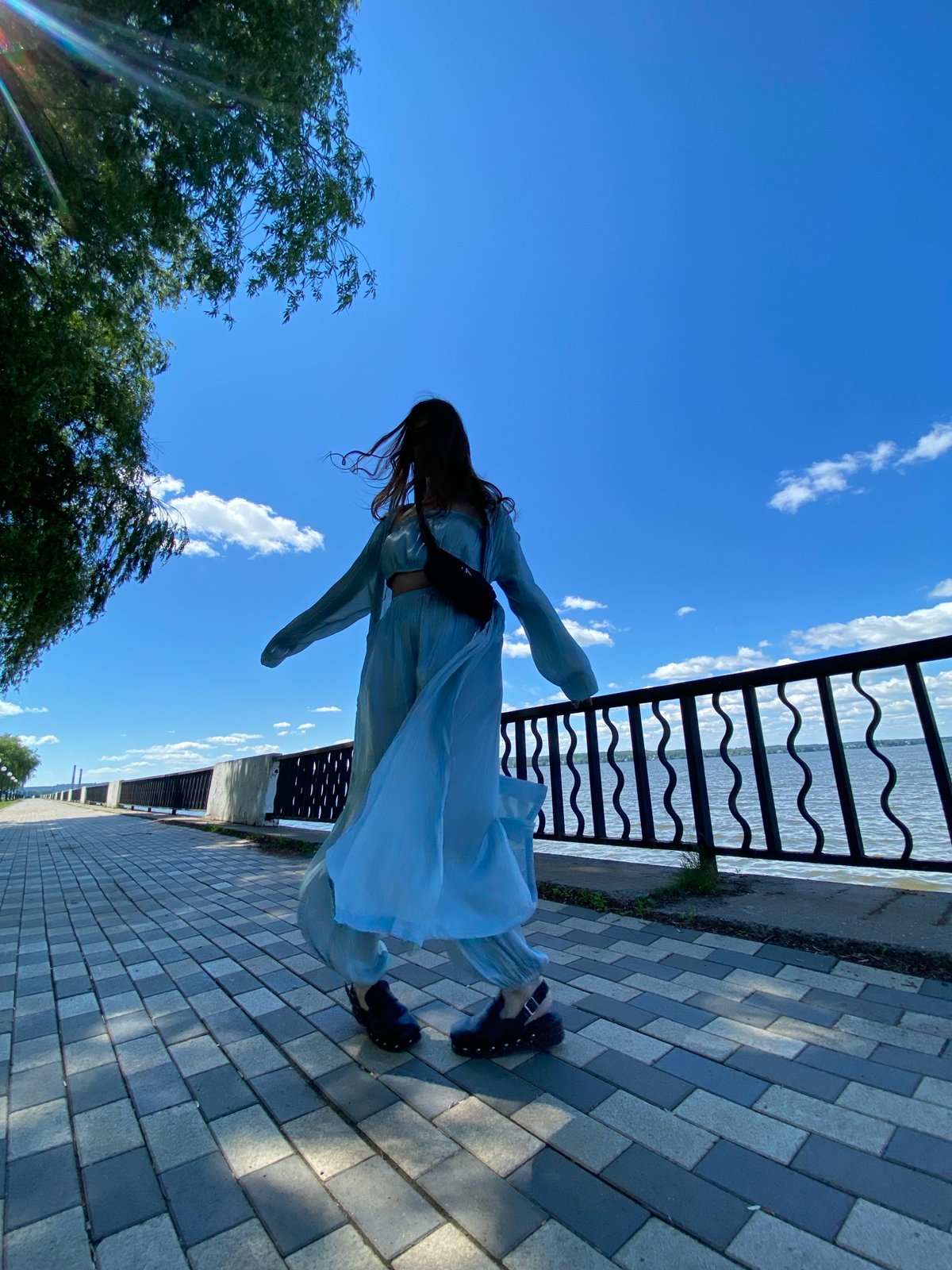 Woman in light blue outfit spotted outdoors in sunny weather