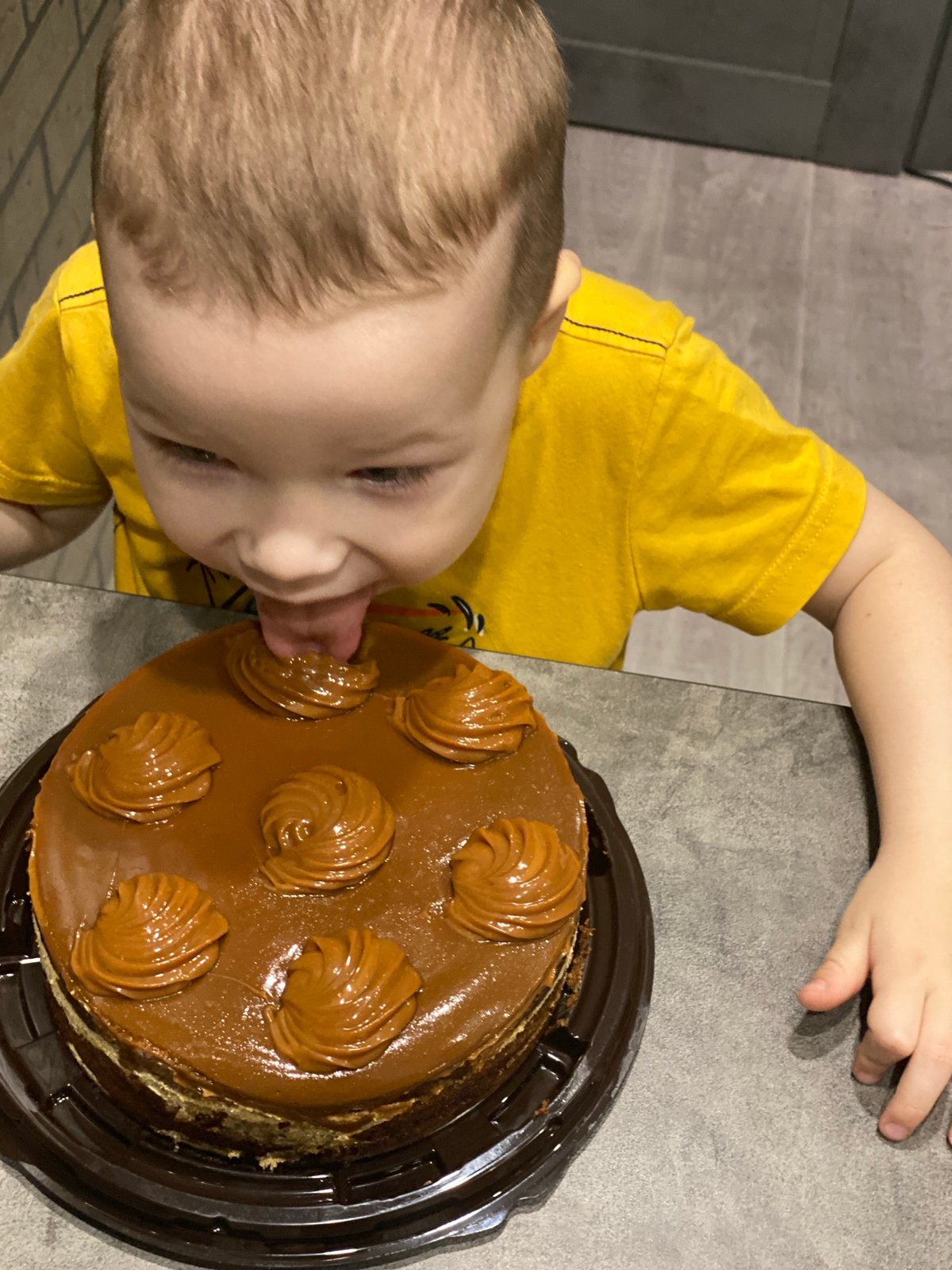 Child enjoys caramel cake during sunny afternoon in Sochi