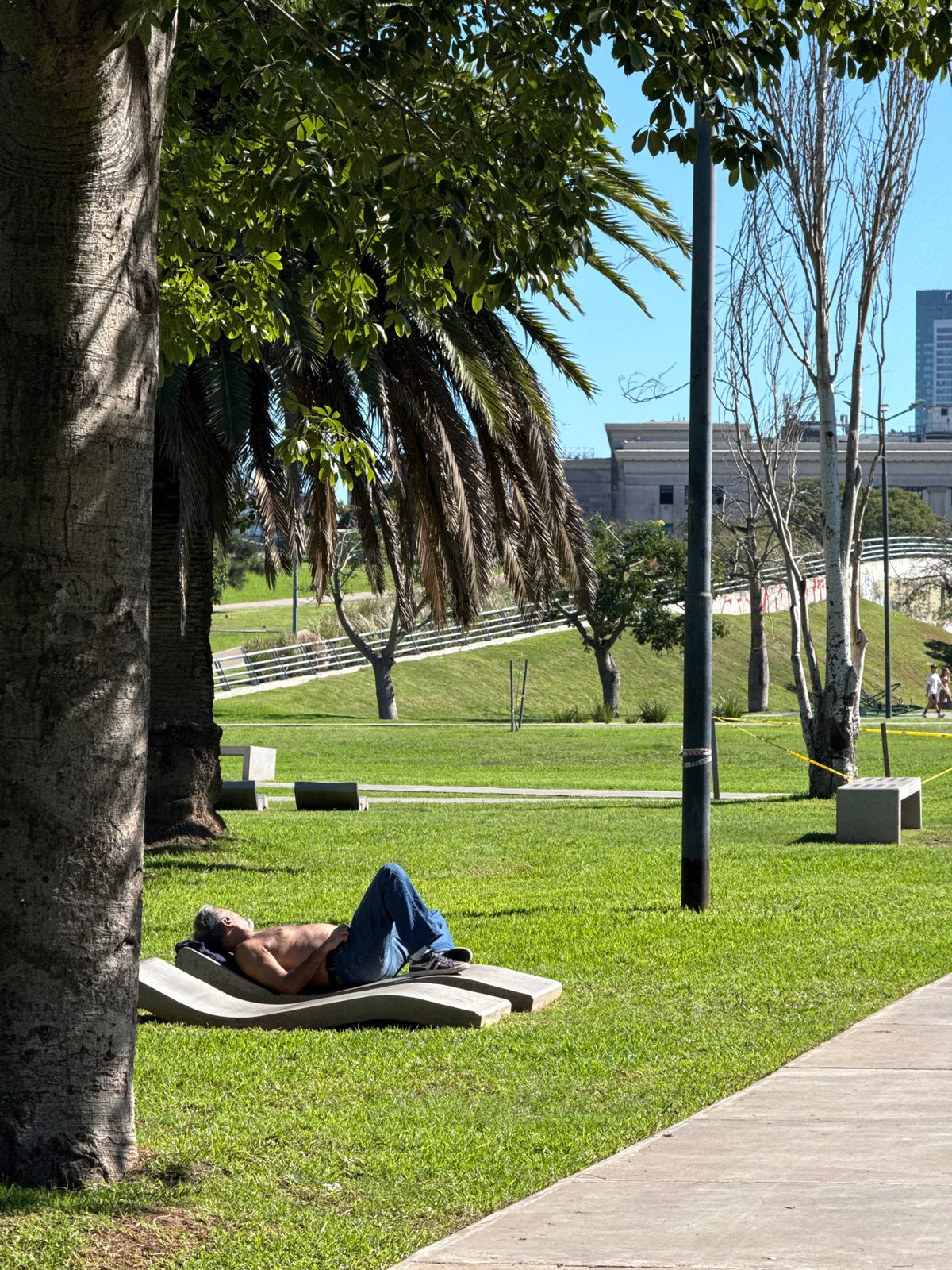 Man rests near bronze sculpture in Buenos Aires park