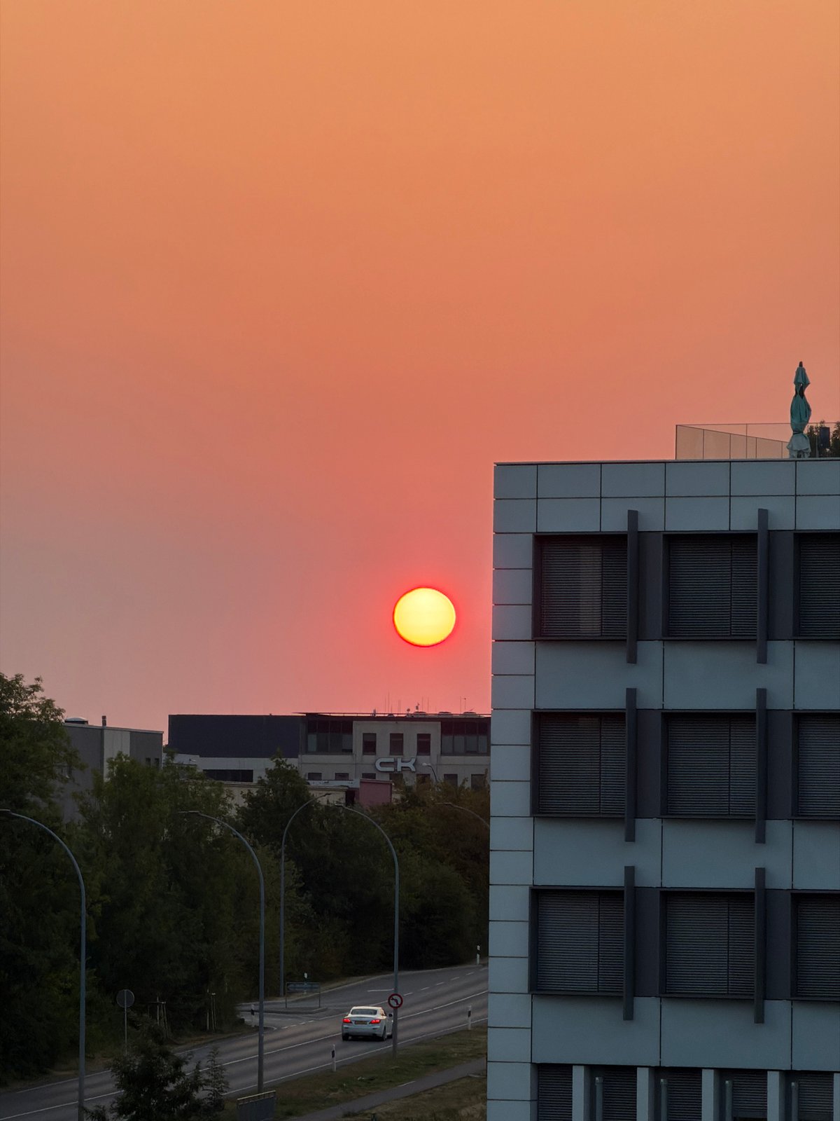 Sunrise over Leudelange's office district, with a departing jet
