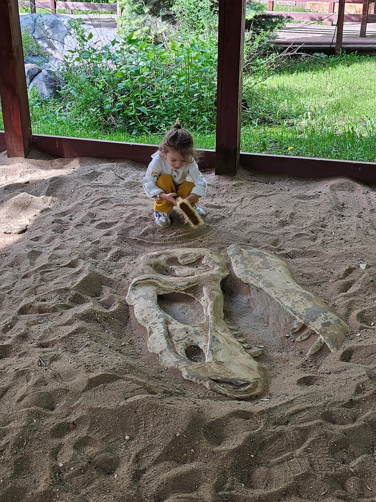 Child plays with dinosaur replicas in Khimki sandbox playground