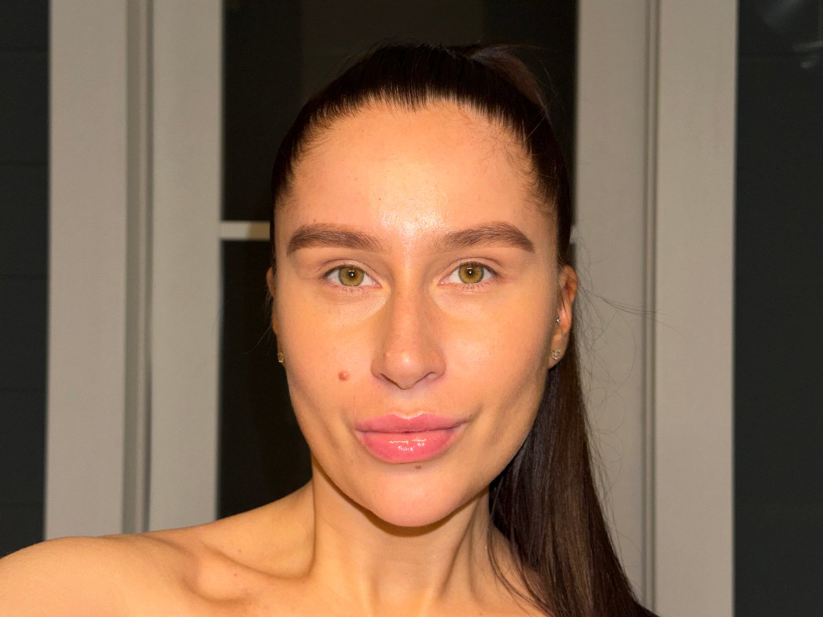 Woman takes bathroom selfies while holding water glass