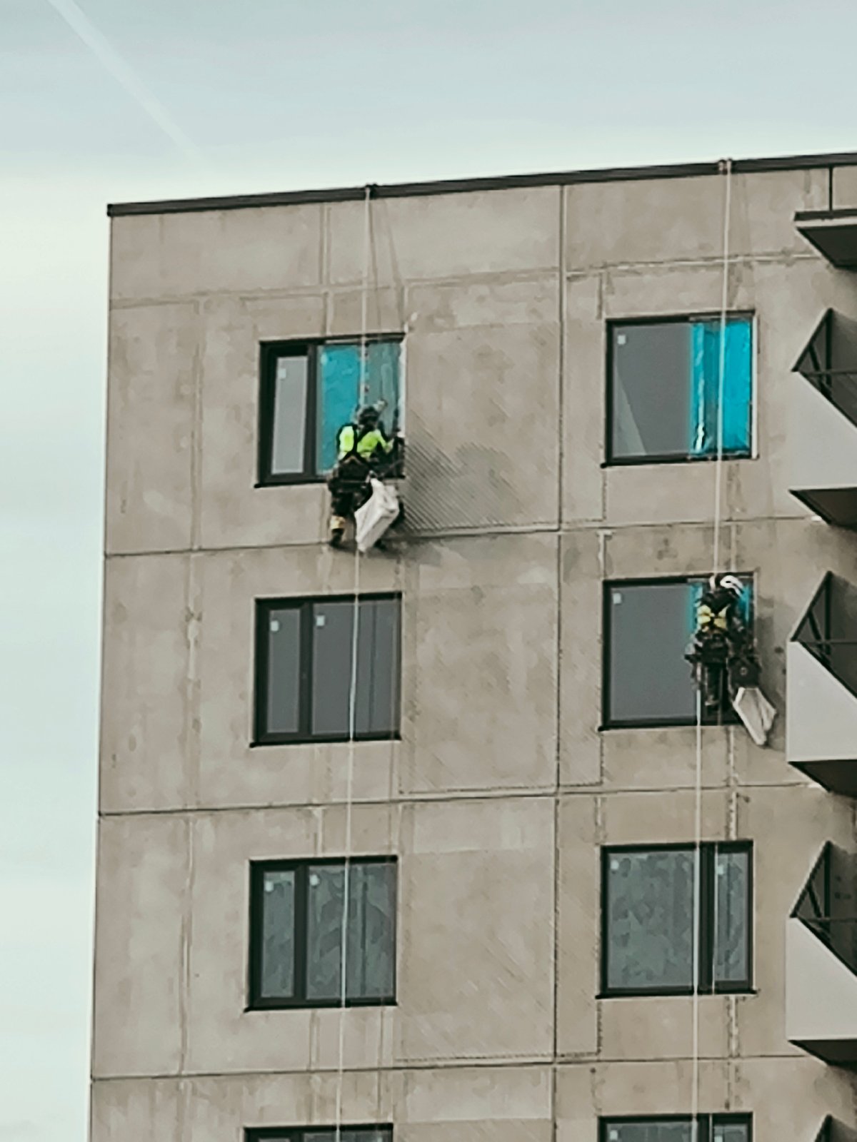 Grey concrete building with dark windows observed in Riga