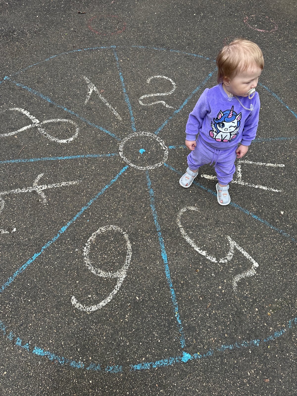 Child stands on chalk clock drawing in Nizhny Novgorod