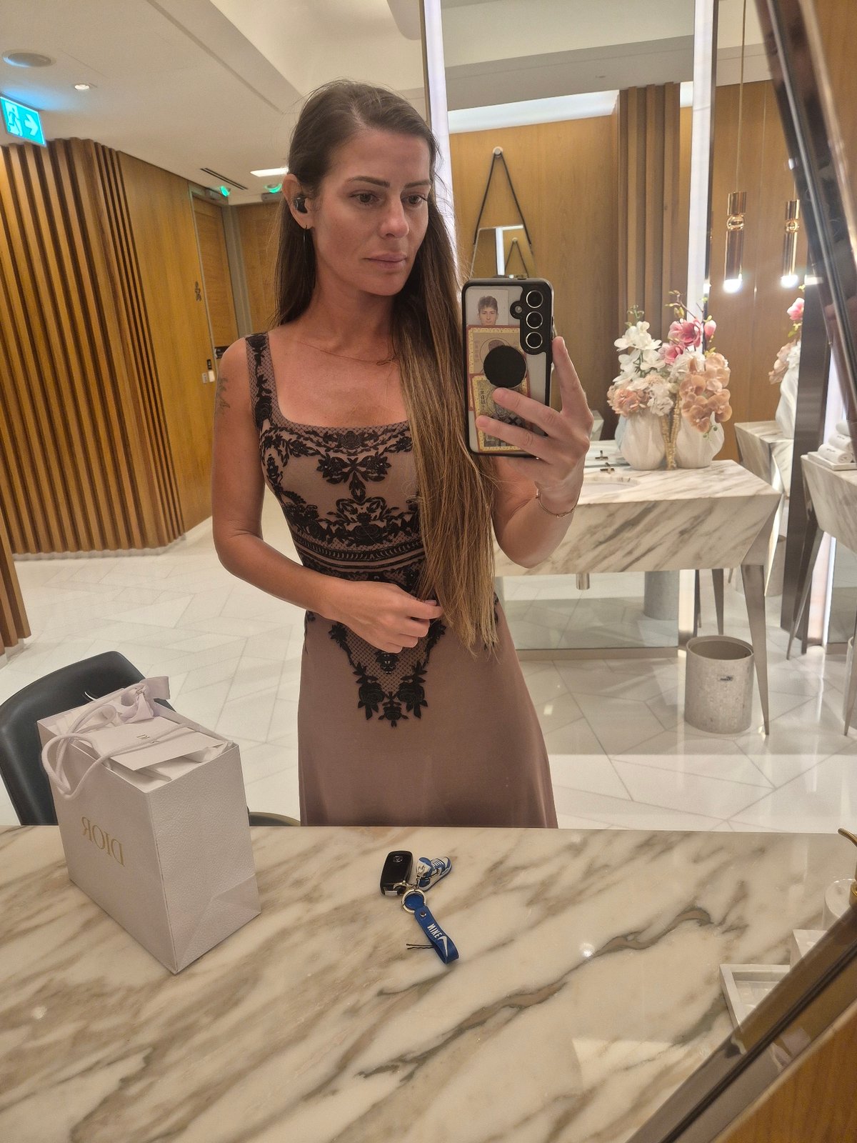 Woman takes mirror selfies in upscale indoor setting