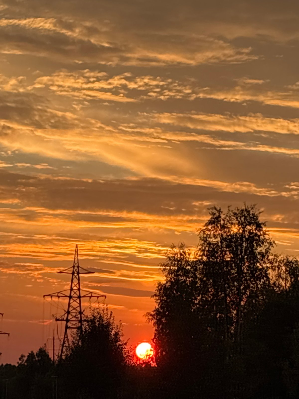 Sunset over Nizhnevartovsk's treeline, sky shifting through warm tones