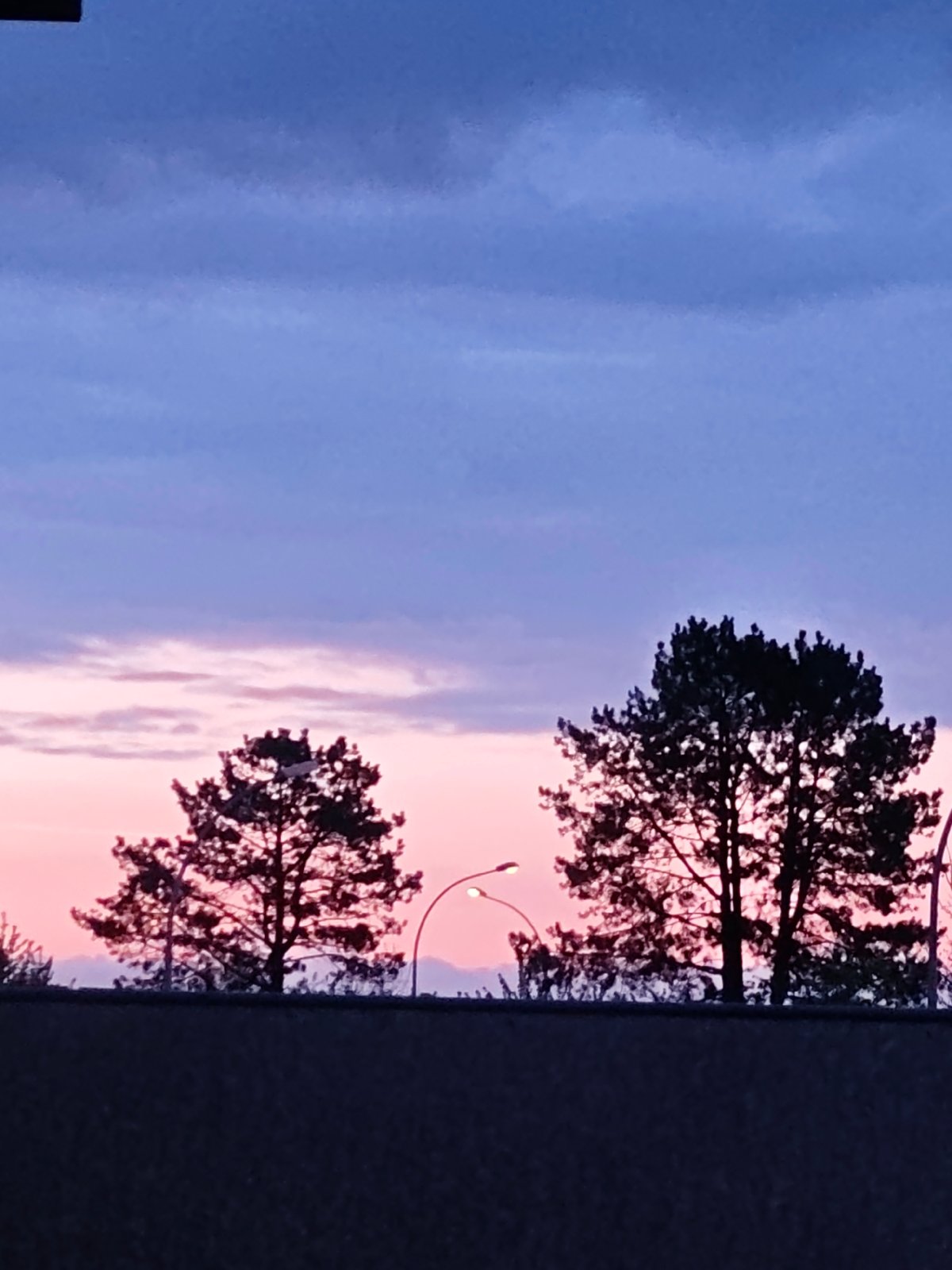Dawn sky with pink hues observed over concrete wall in Leudelange